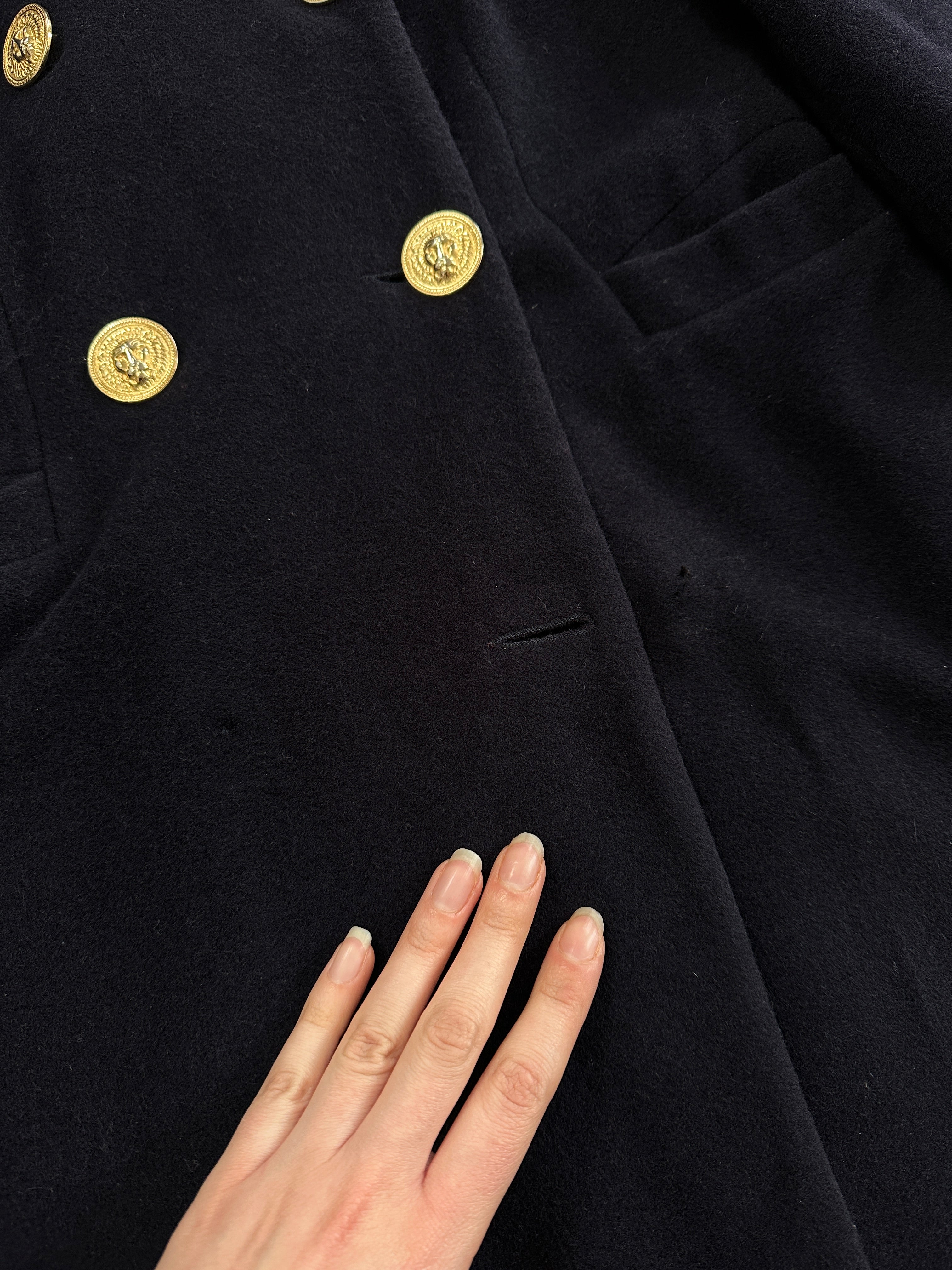 Gianni Versace Versus 1990s bespoke double-breasted coat in black, tailored with buttons, displayed on a hanger.