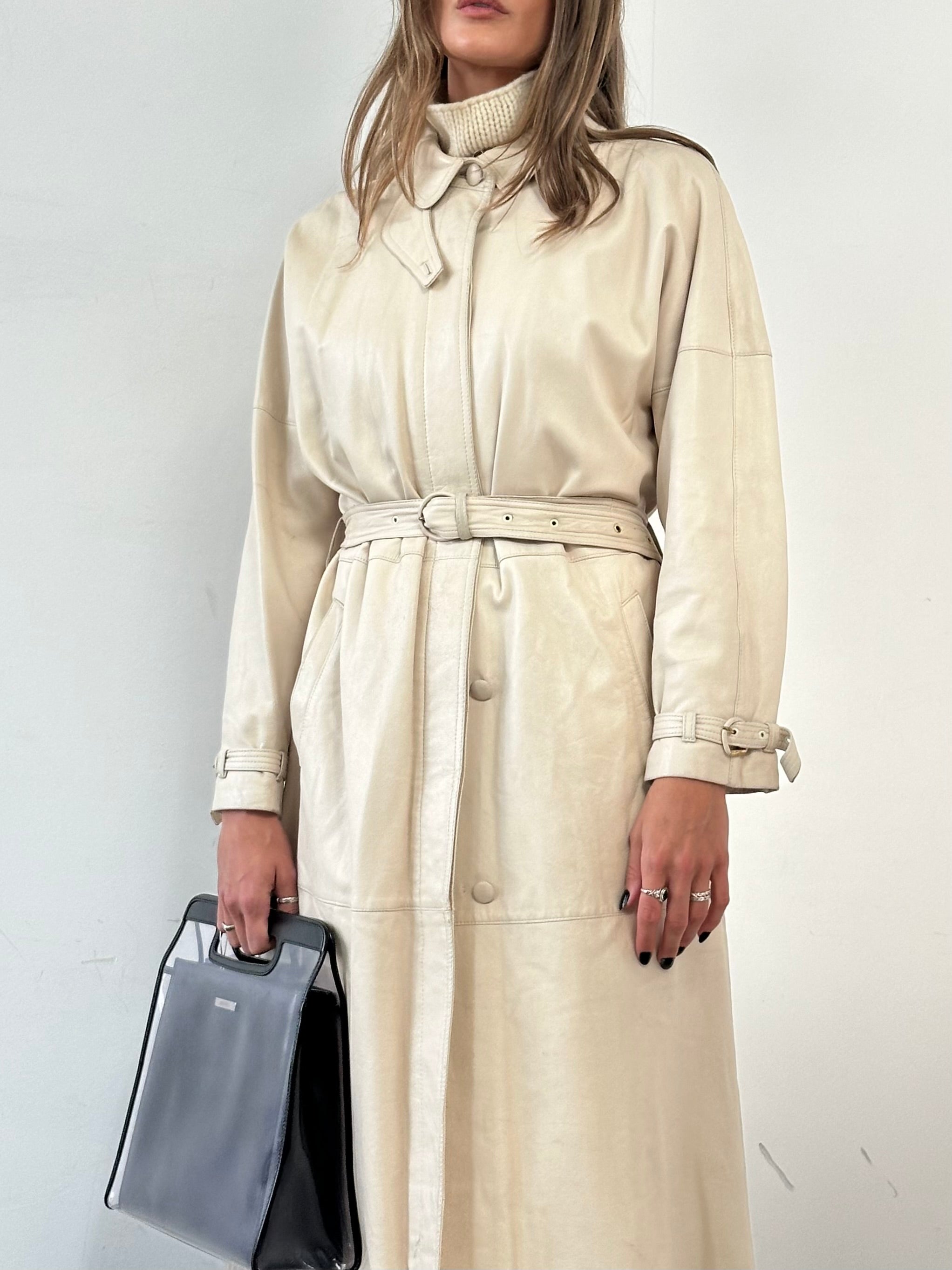 Vintage leather trench coat with belt, classic design, shown in natural tan color, tailored fit, and detailed lapels.