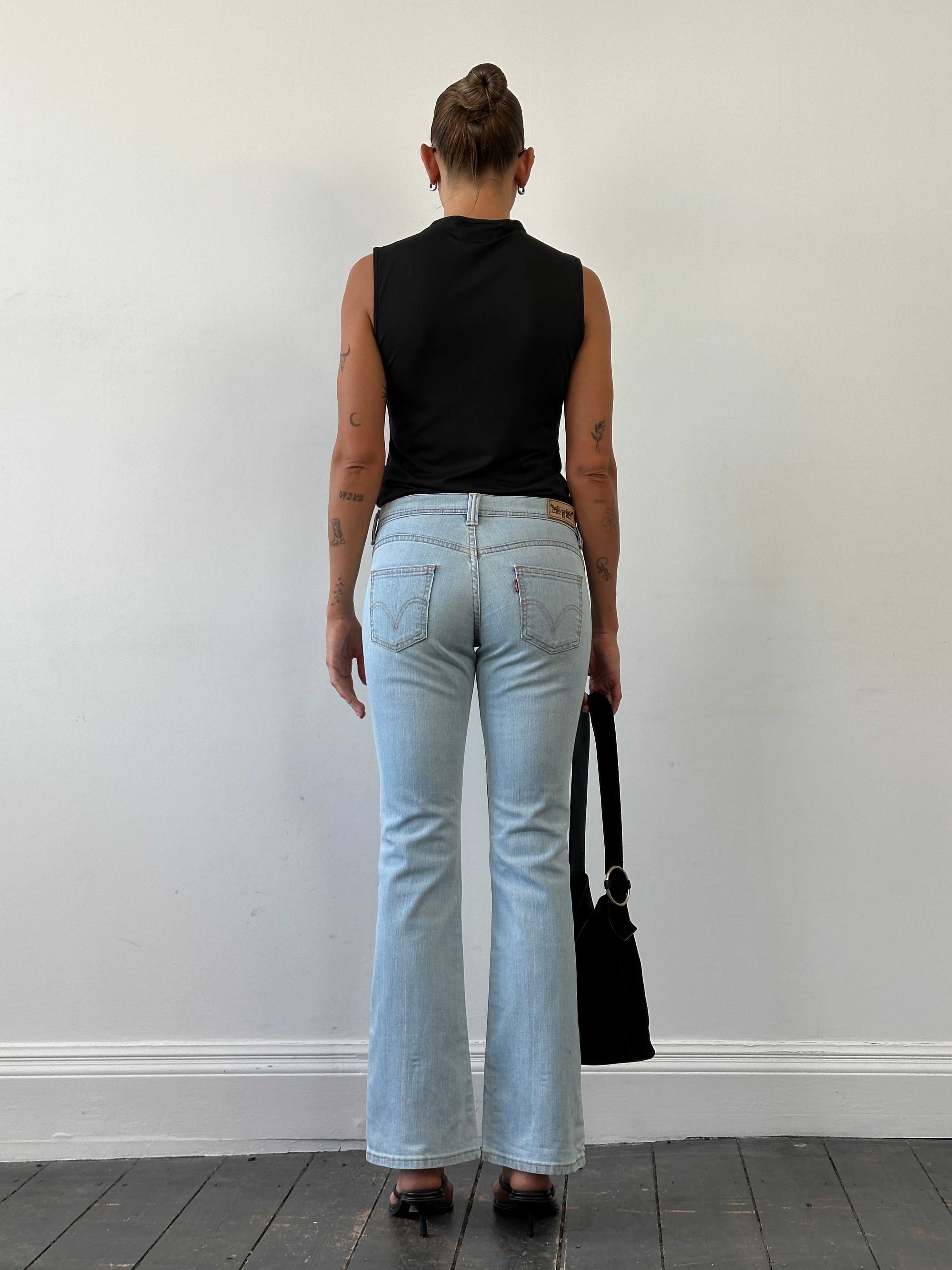 Levi’s low waist flared denim jeans in size W28, showing the classic fit with a flared leg and light blue denim fabric.