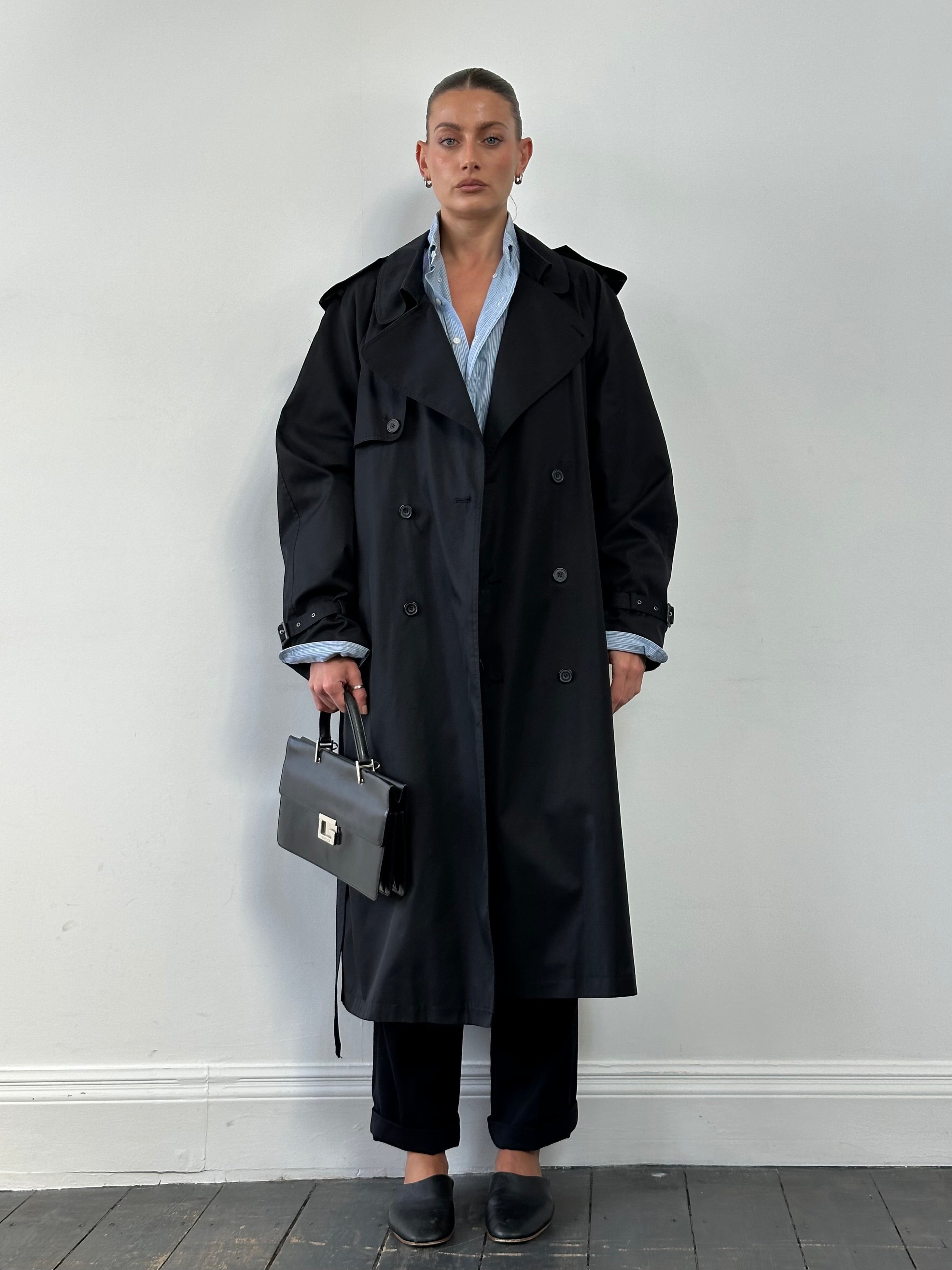 Vintage double-breasted belted trench coat in size XL, classic style with front pockets and a timeless design.