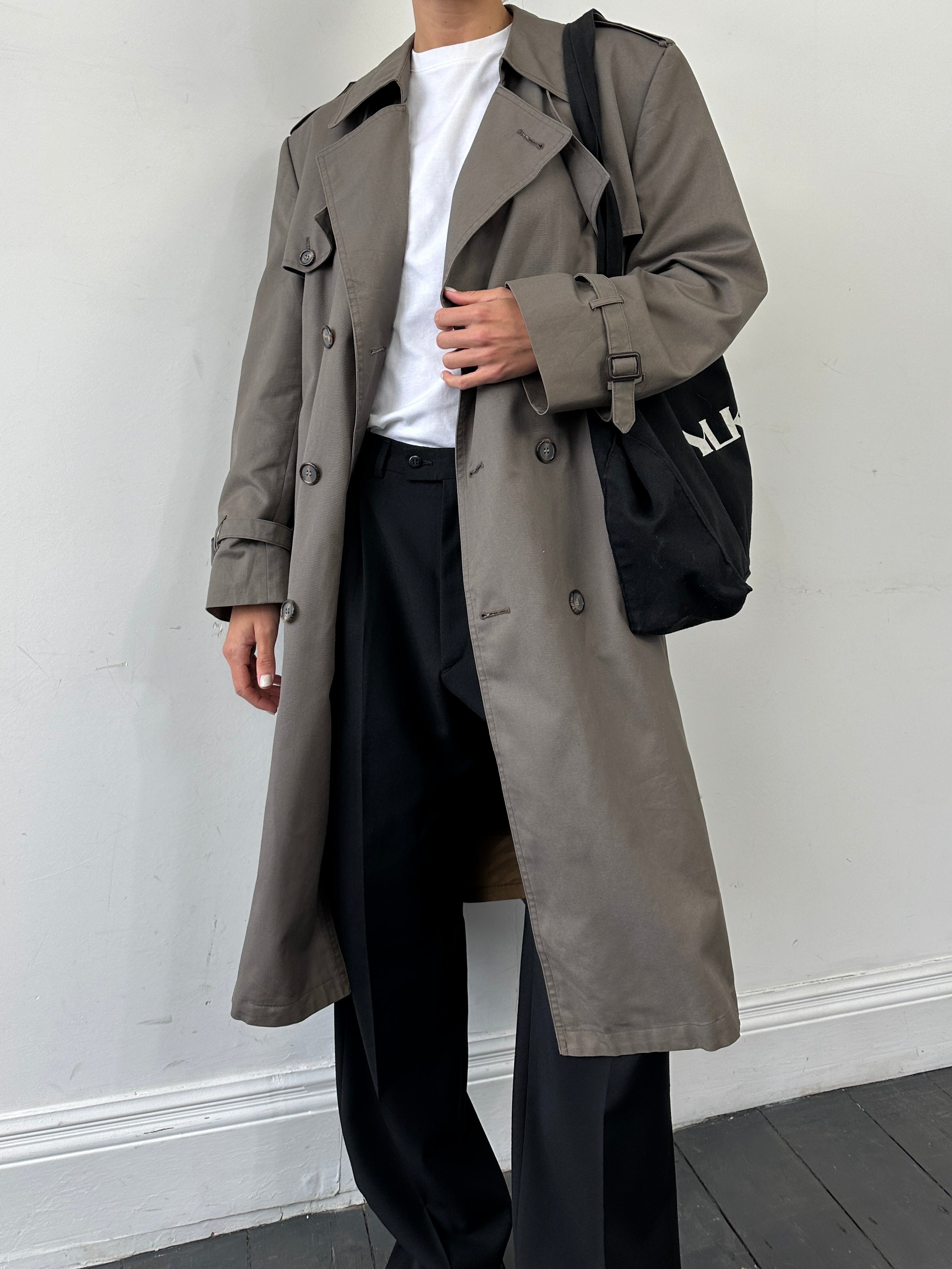 Christian Dior Monsieur double-breasted belted trench coat in classic beige, displayed on a hanger with detailed fabric texture.