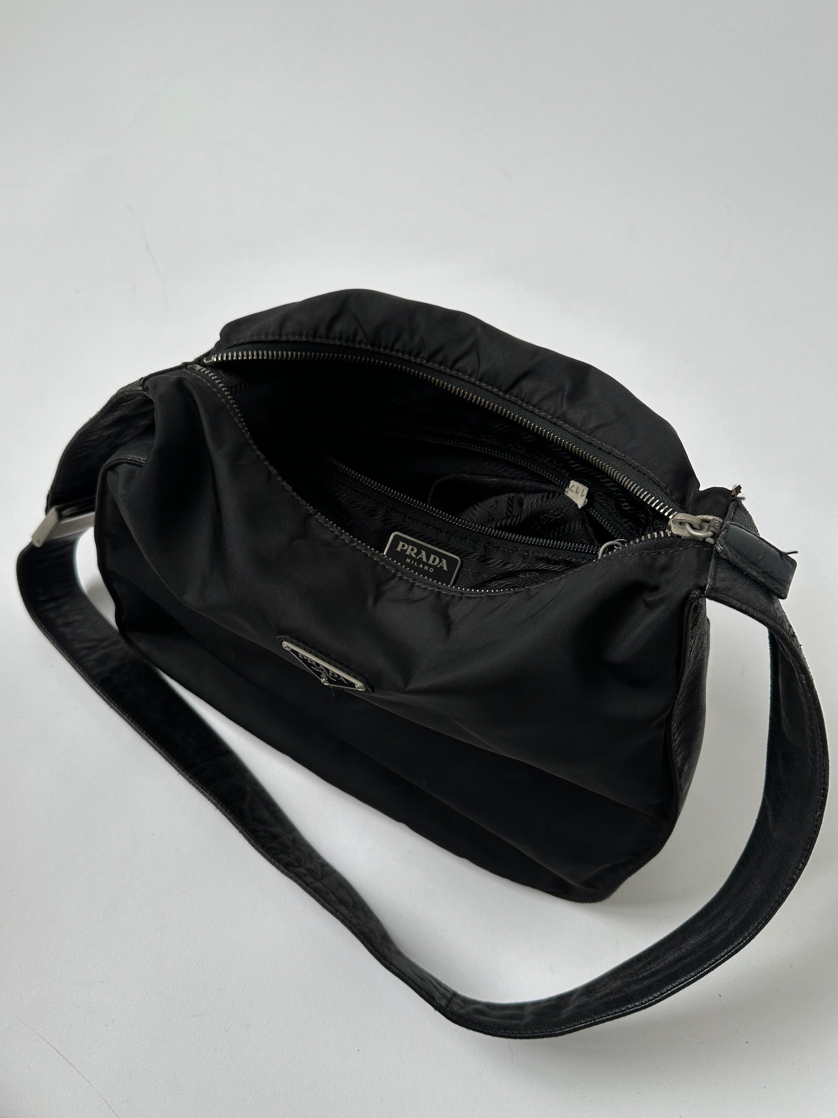 Prada nylon and leather crossbody bag with adjustable strap and sleek design, featuring the iconic Prada logo.