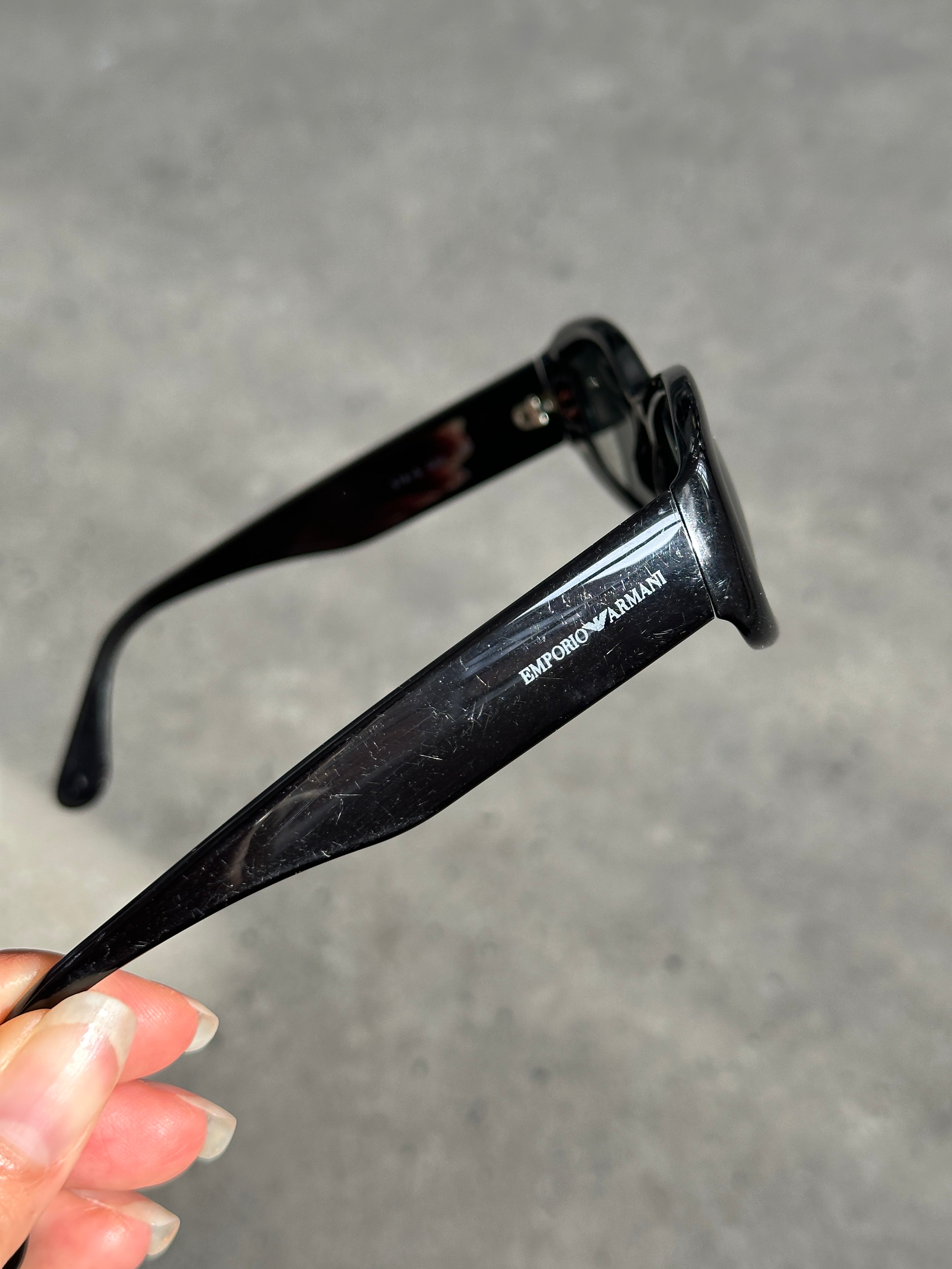 Emporio Armani oval sunglasses with black frames and dark lenses, stylish and modern eyewear for sun protection.