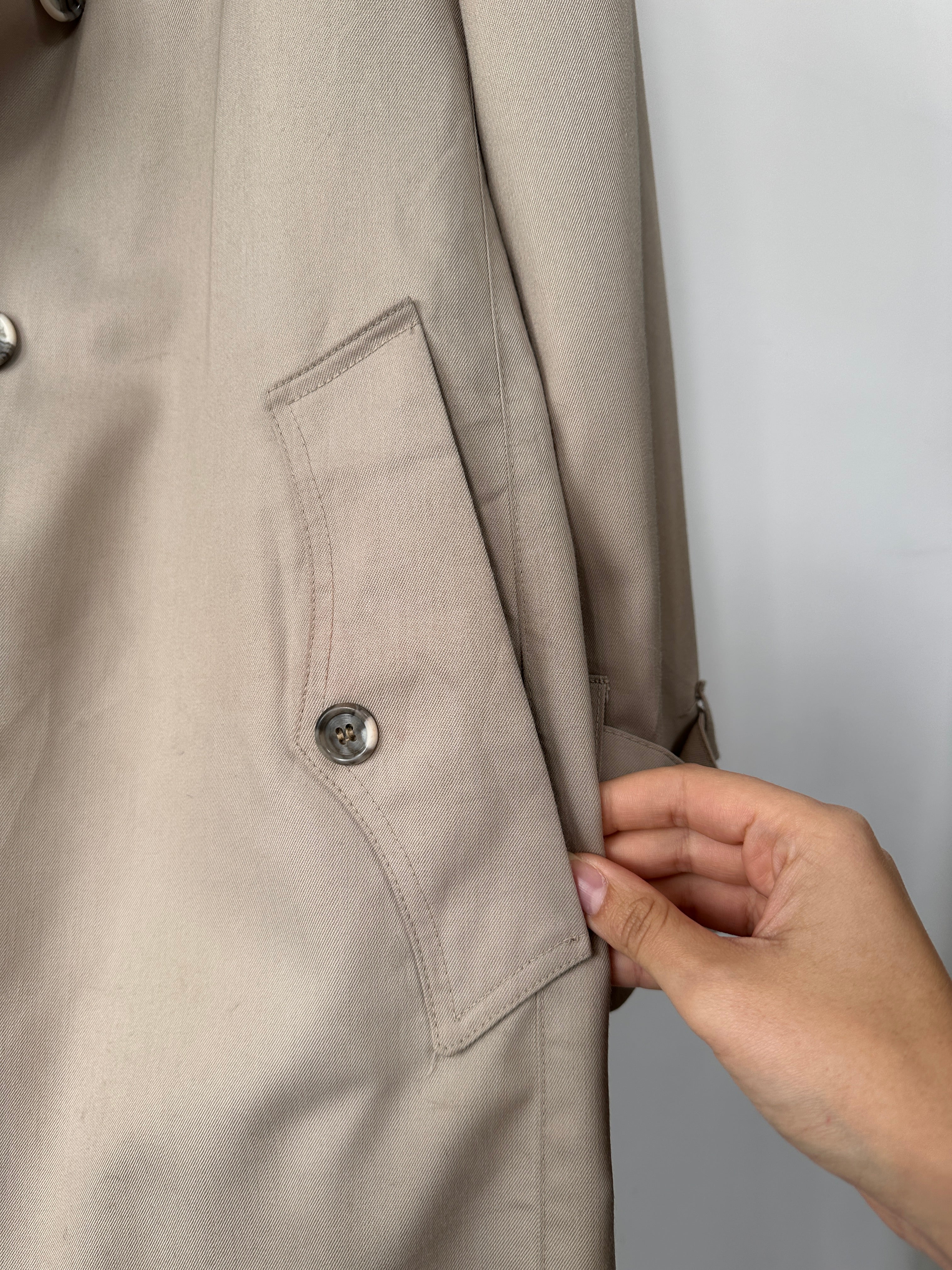 Christian Dior double-breasted trench coat in XL/XXL, shown on a hanger with classic beige fabric and stylish design details.