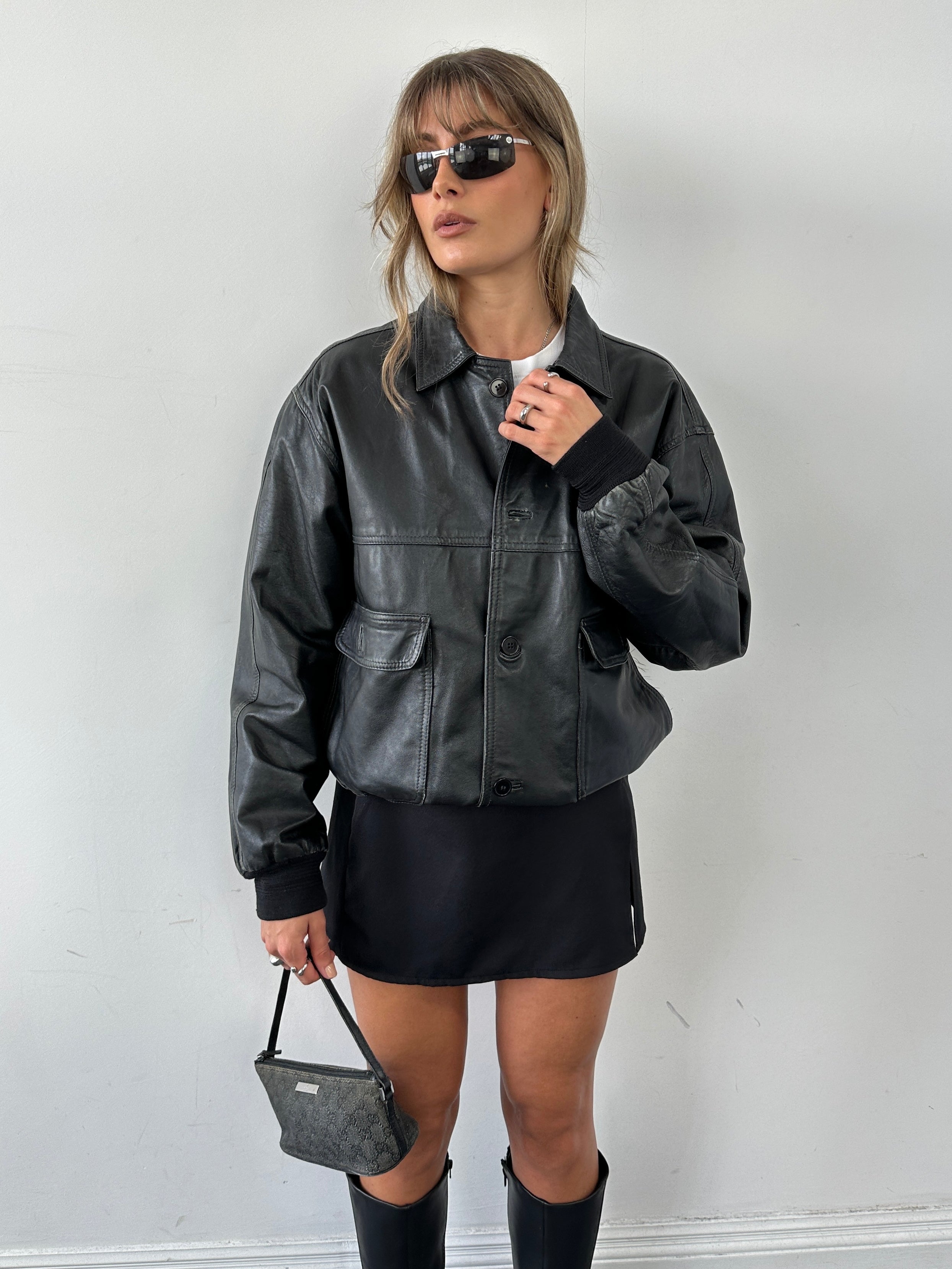 Vintage leather bomber jacket in size M, featuring classic design with a smooth leather finish and ribbed collar and cuffs.