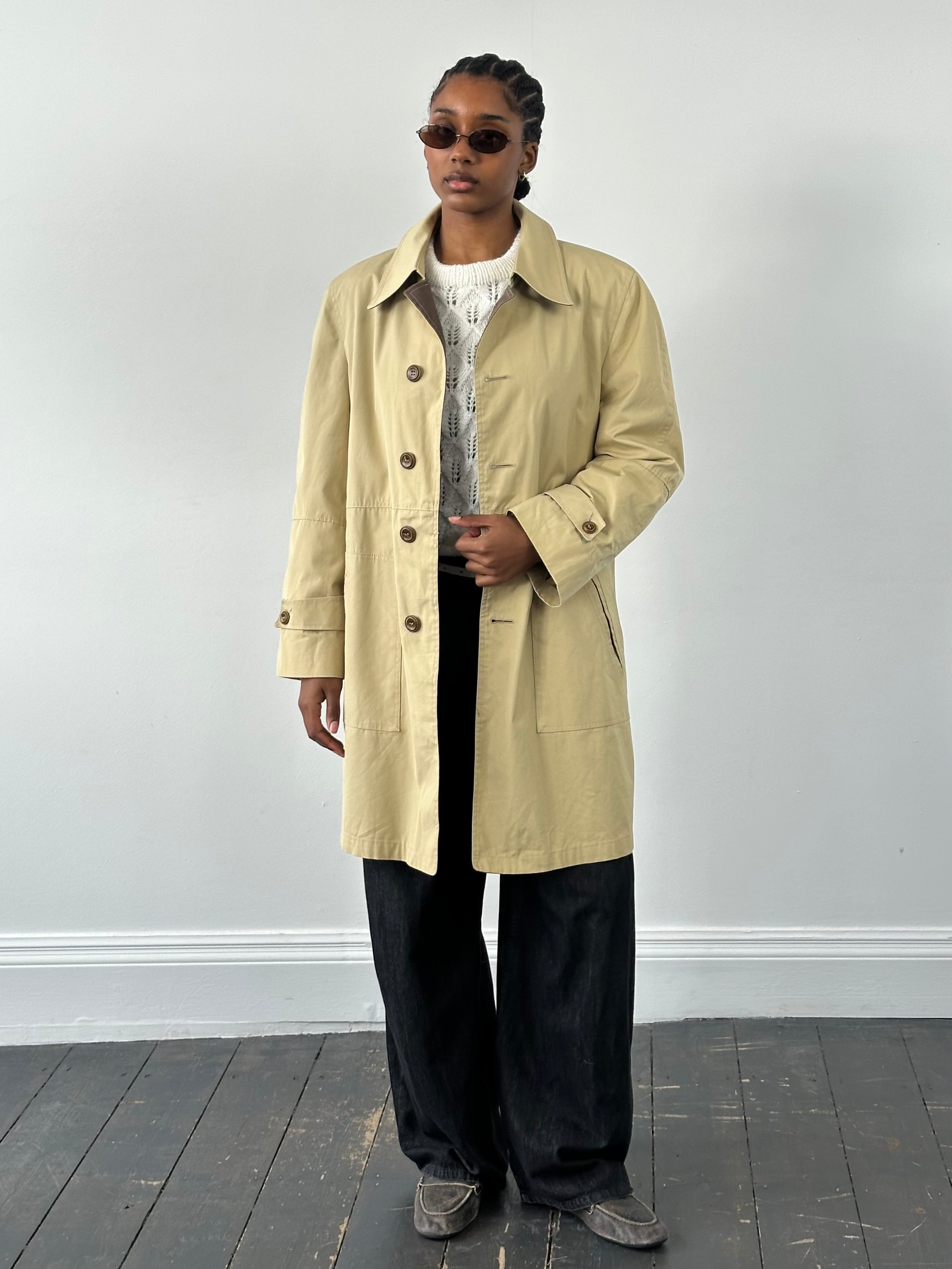 Christian Dior Paris 1980s cotton belted trench coat shown on a model, featuring classic design and neutral color.