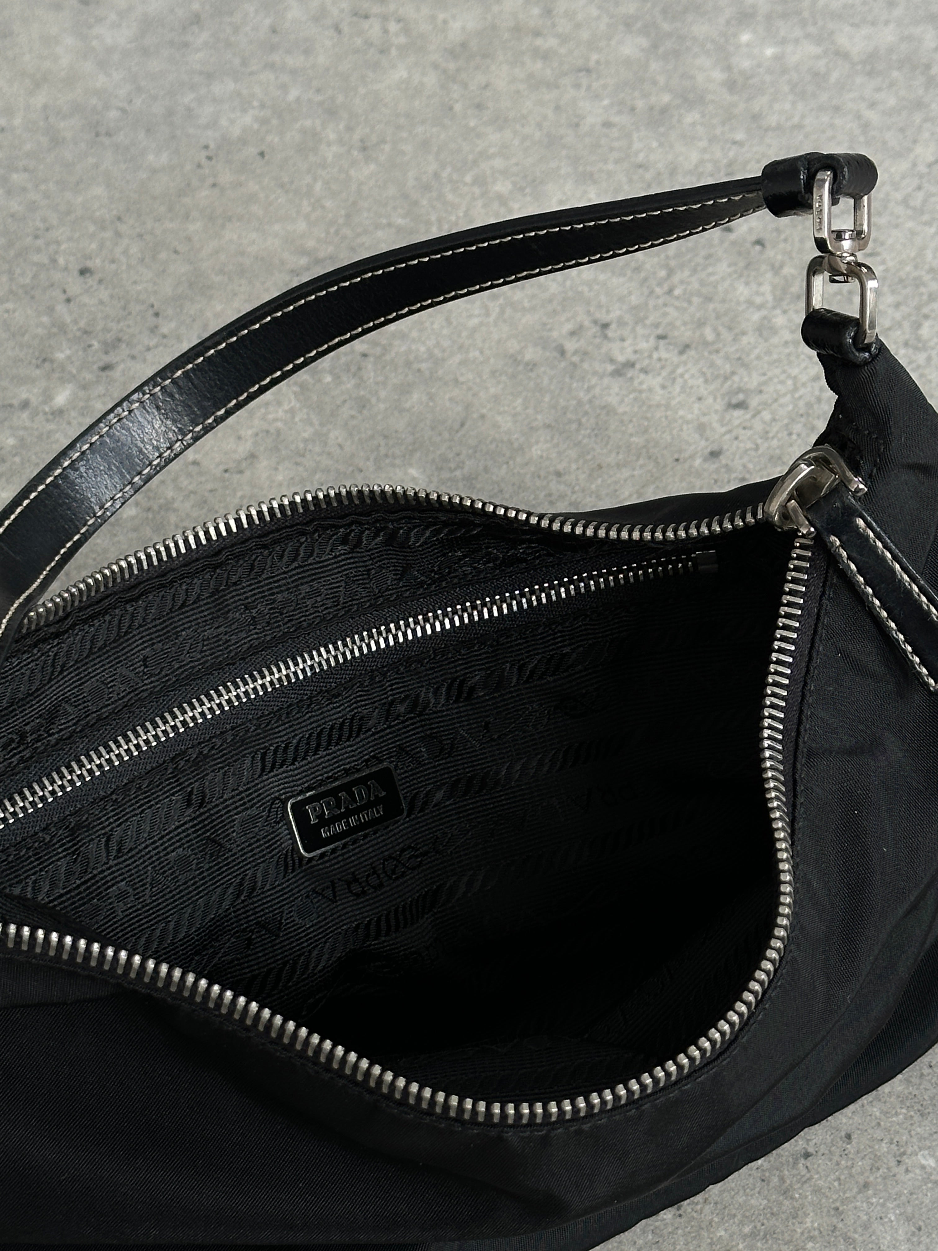 Prada nylon shoulder bag with chrome logo hardware featuring a sleek design and adjustable strap.