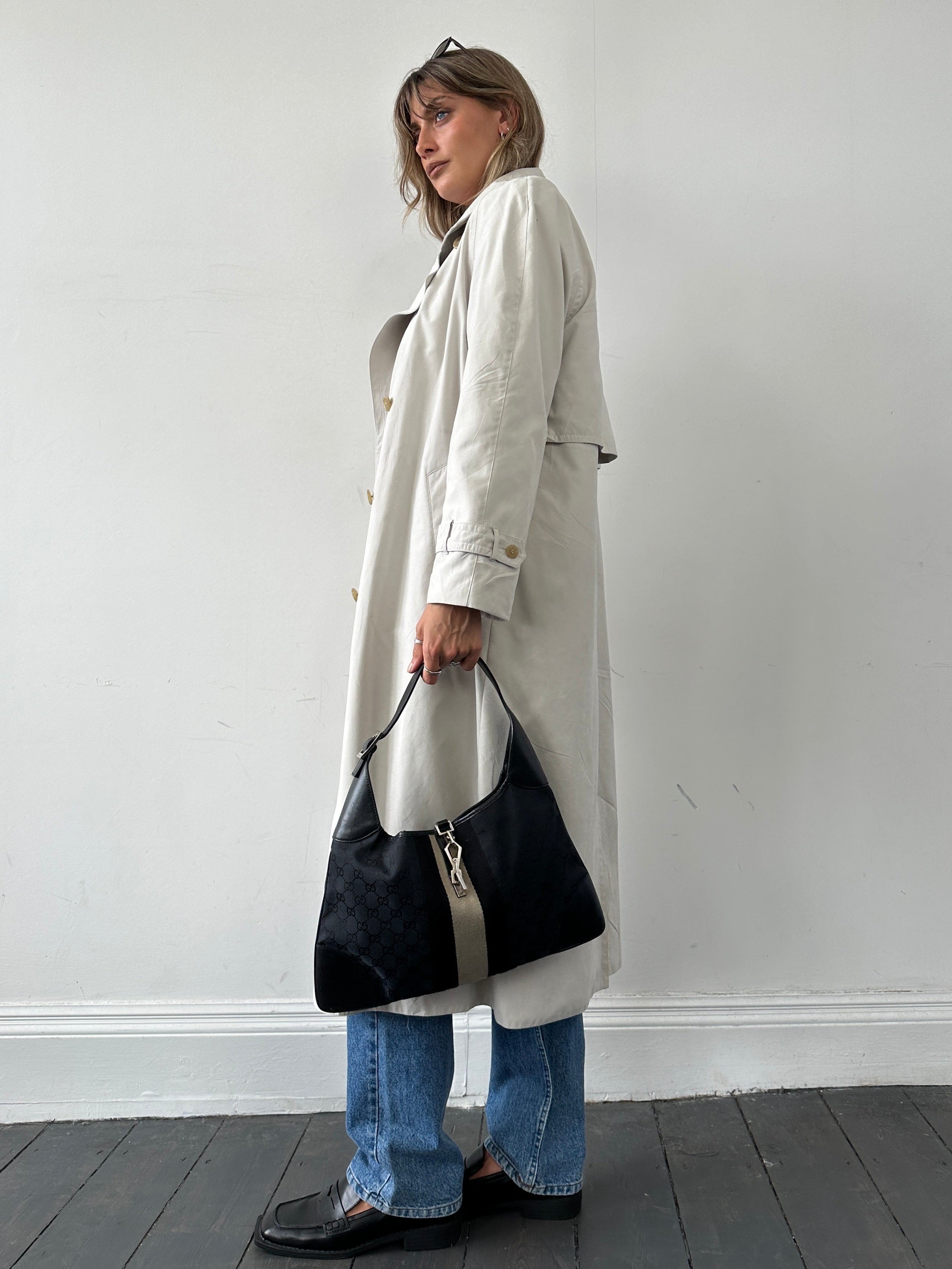 Vintage brand vintage floor length trench coat in size L, showcasing classic design and beige fabric with a belt and collar detail.