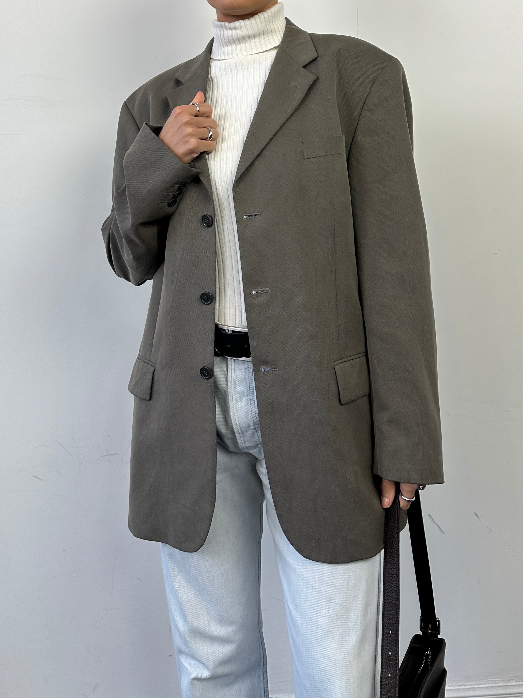Vintage relaxed single-breasted blazer in size L/XL, tailored fit with classic lapels and stylish design, shown on a hanger.
