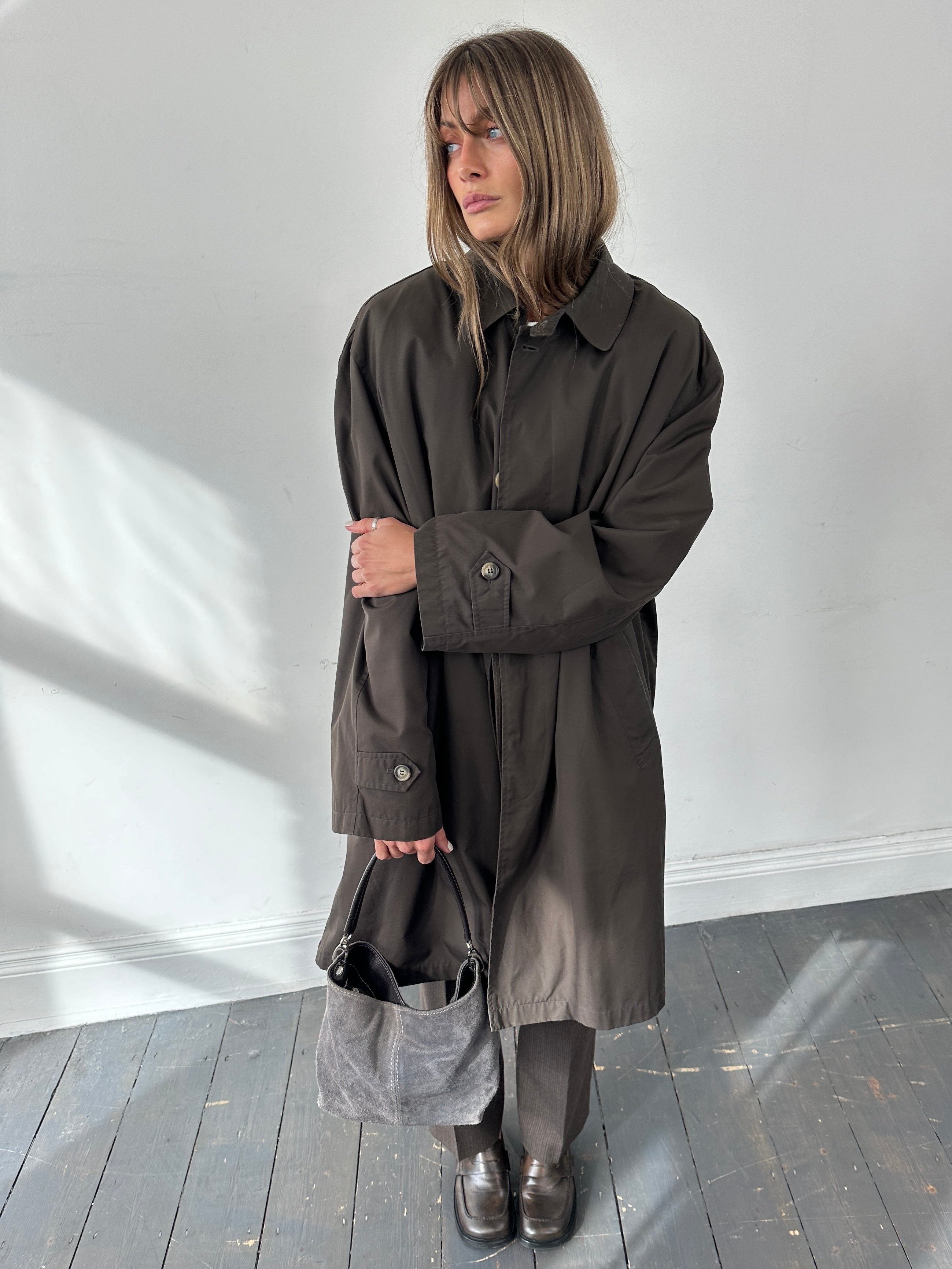 Vintage XXL trench coat with concealed placket, classic beige color, and tailored fit, displayed on a hanger against a neutral background.