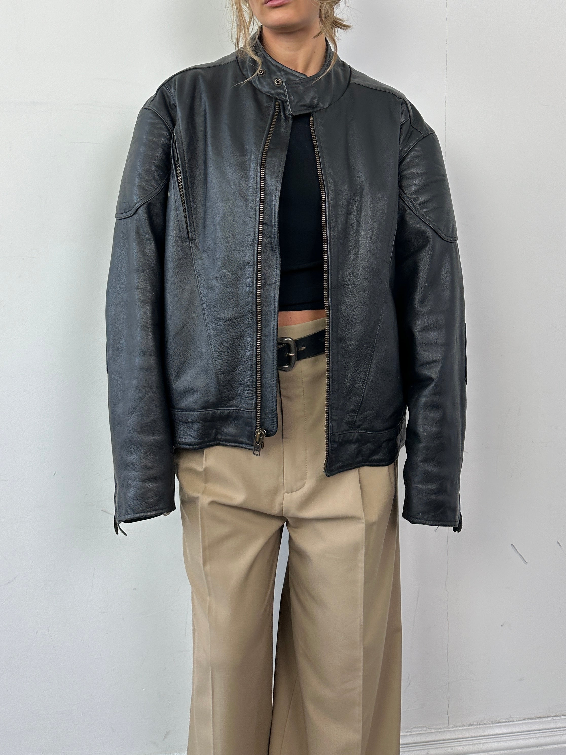 Vintage leather motorcycle jacket in XL size, featuring classic design with sturdy leather and metal accents, perfect for motorcycle enthusiasts.