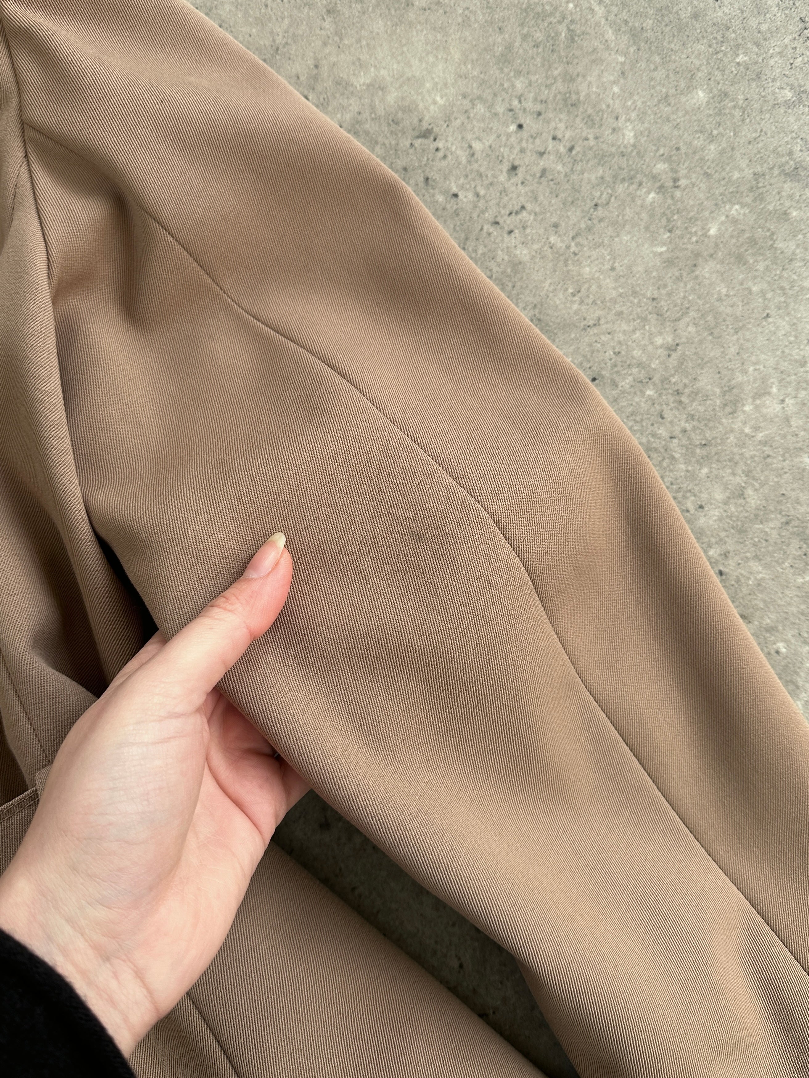 Vintage pure virgin wool double-breasted belted trench coat in beige, displayed on a hanger with classic design details.