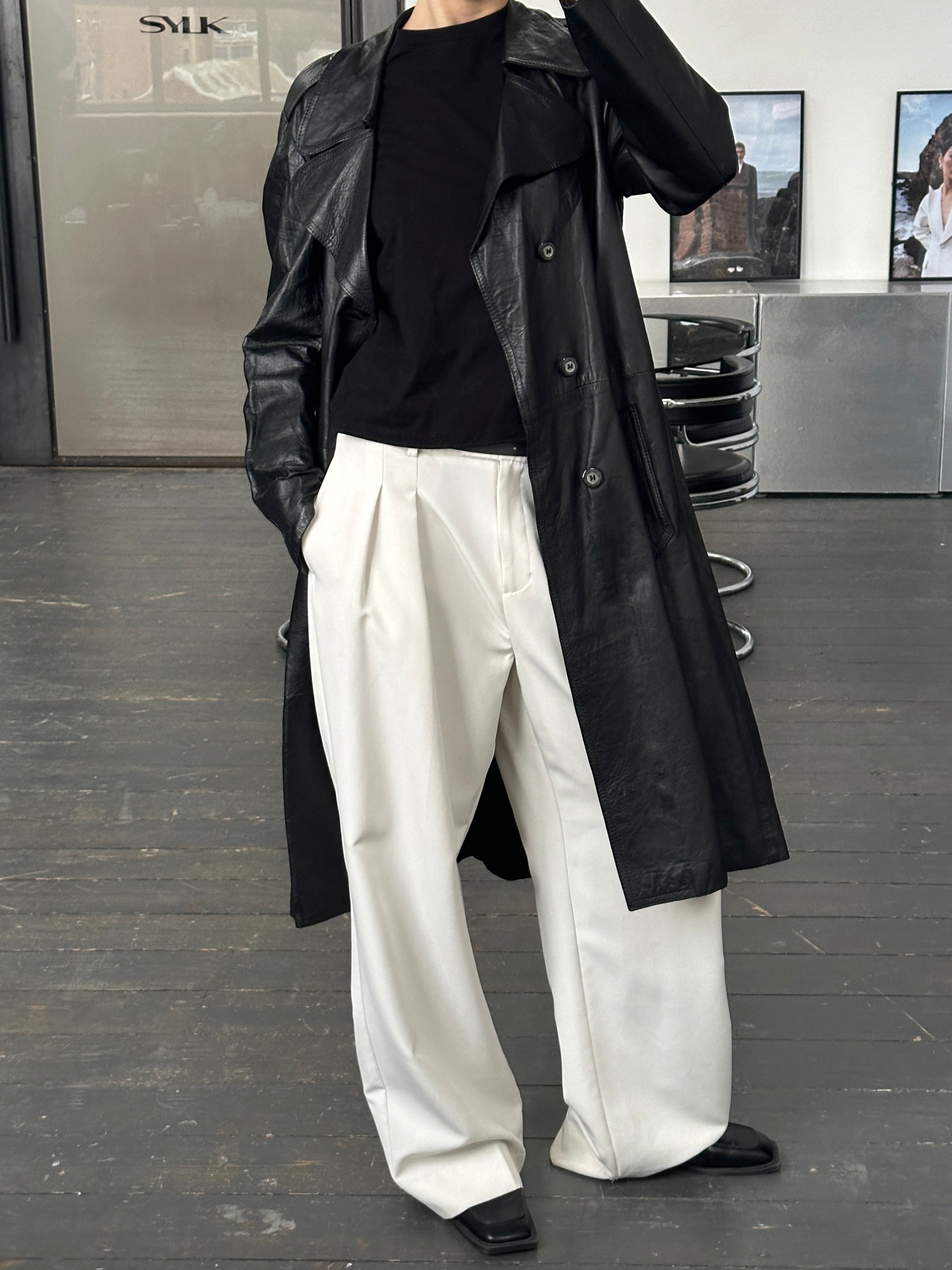 Vintage 1990s leather double-breasted trench coat, stylish and classic, shown on a hanger in this image.