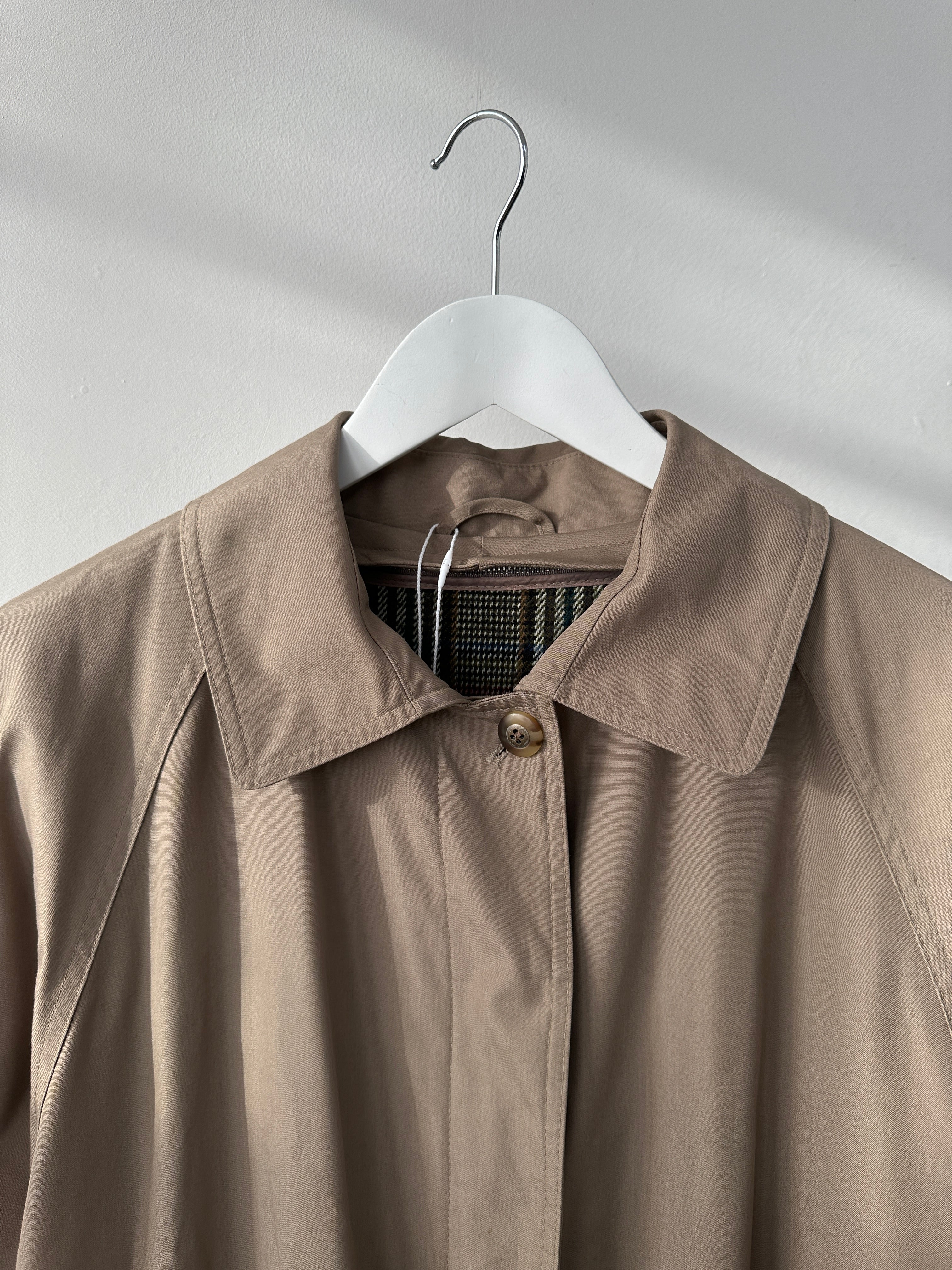Vintage water-resistant trench coat with concealed placket in M/L size, stylish vintage coat perfect for rainy weather.