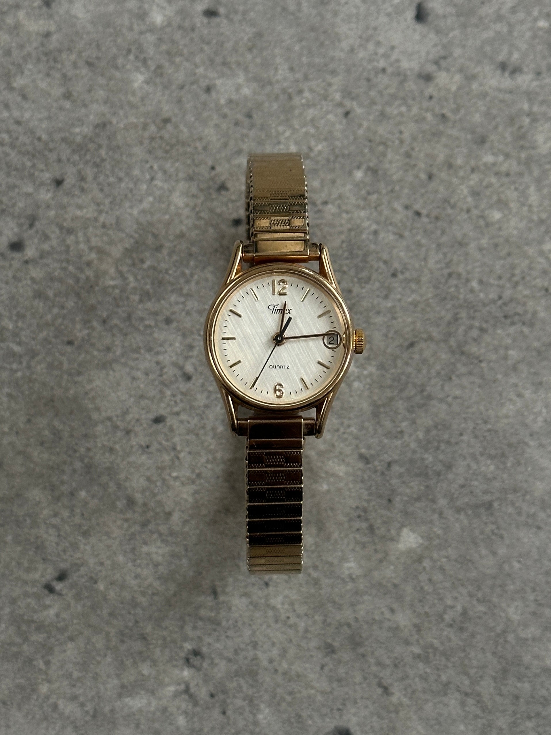 Timex 1990s round gold-tone quartz watch with a classic design and metal band, showcasing a vintage timepiece.