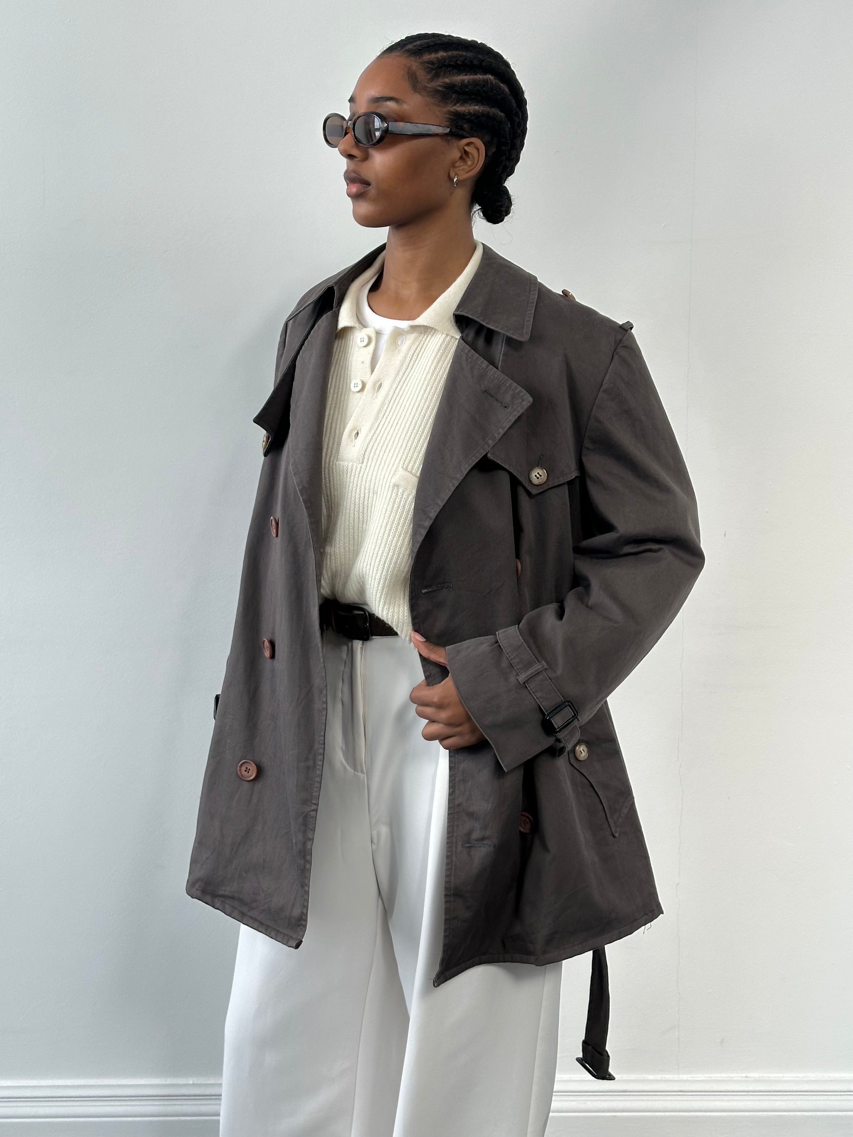 Christian Dior Le Connaisseur 1980s cropped cotton belted trench coat displayed on a hanger, showcasing classic design and tailored fit.