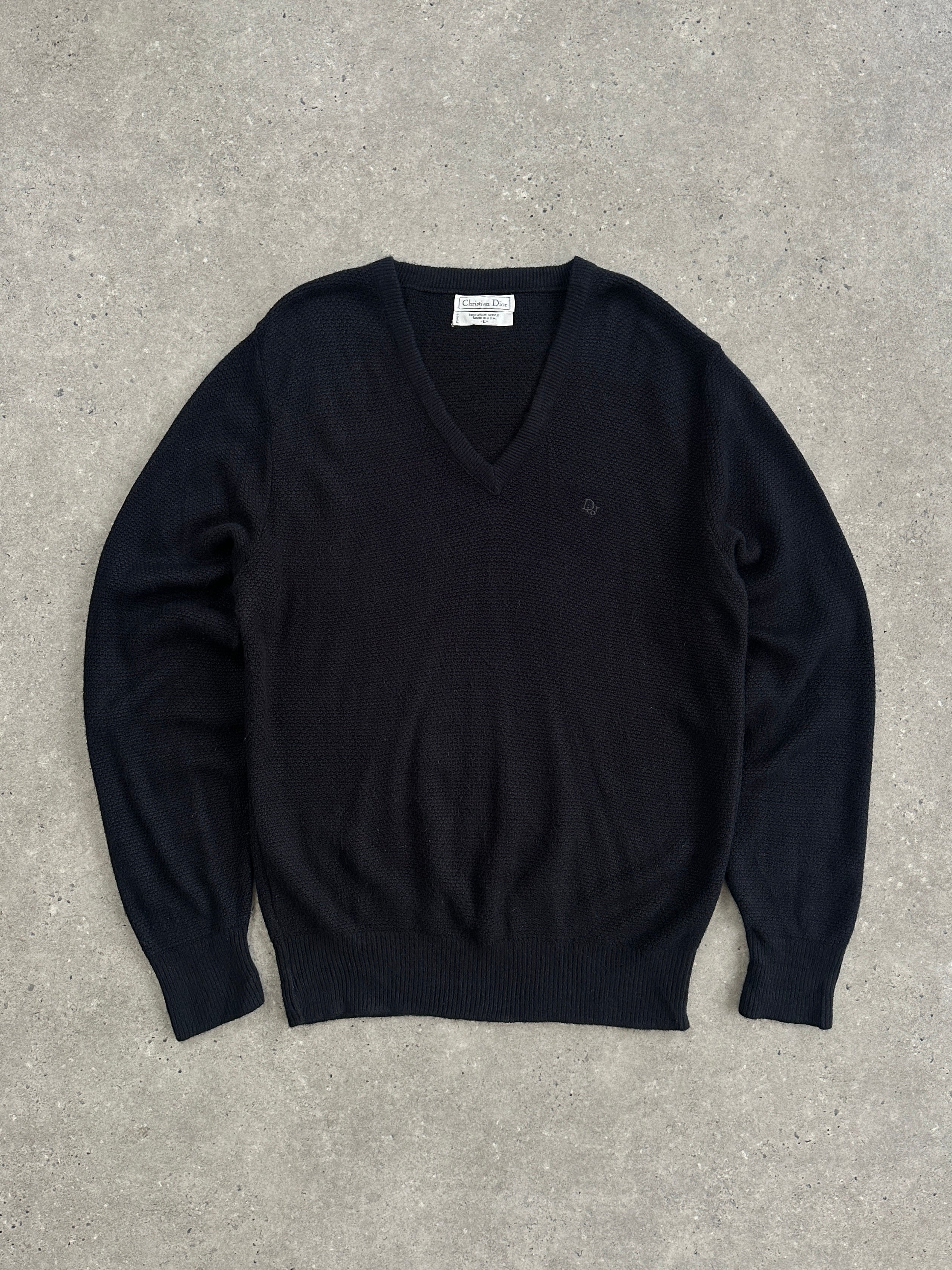 Christian Dior V-neck logo knitted jumper in black, featuring the Dior logo on the front, displayed on a hanger.