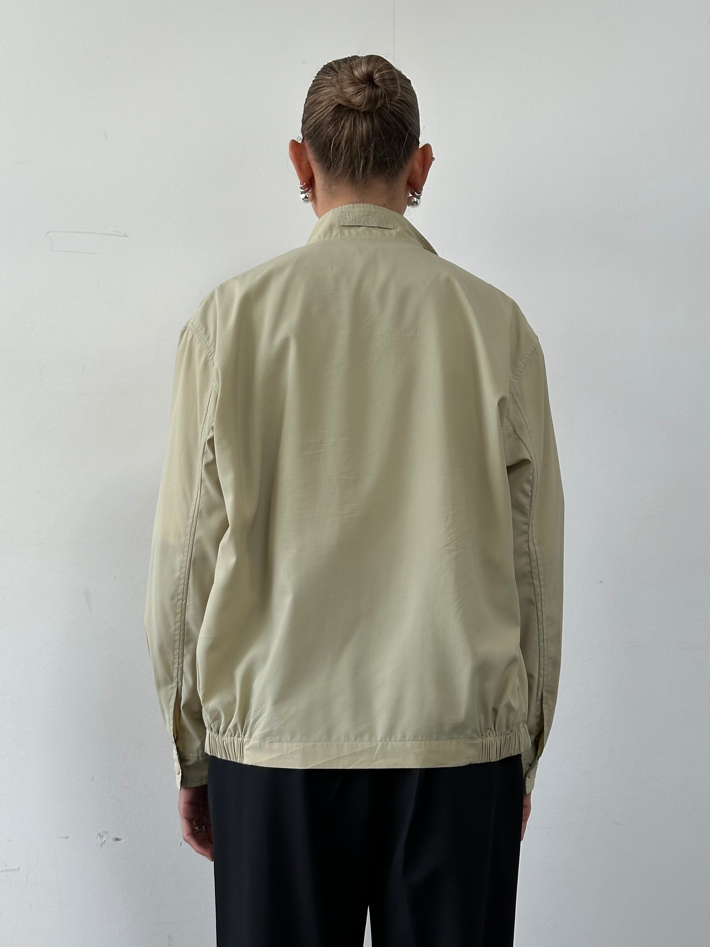 Yves Saint Laurent Pour Homme logo bomber jacket in black with front zipper and ribbed cuffs, size M/L, displayed on a hanger.