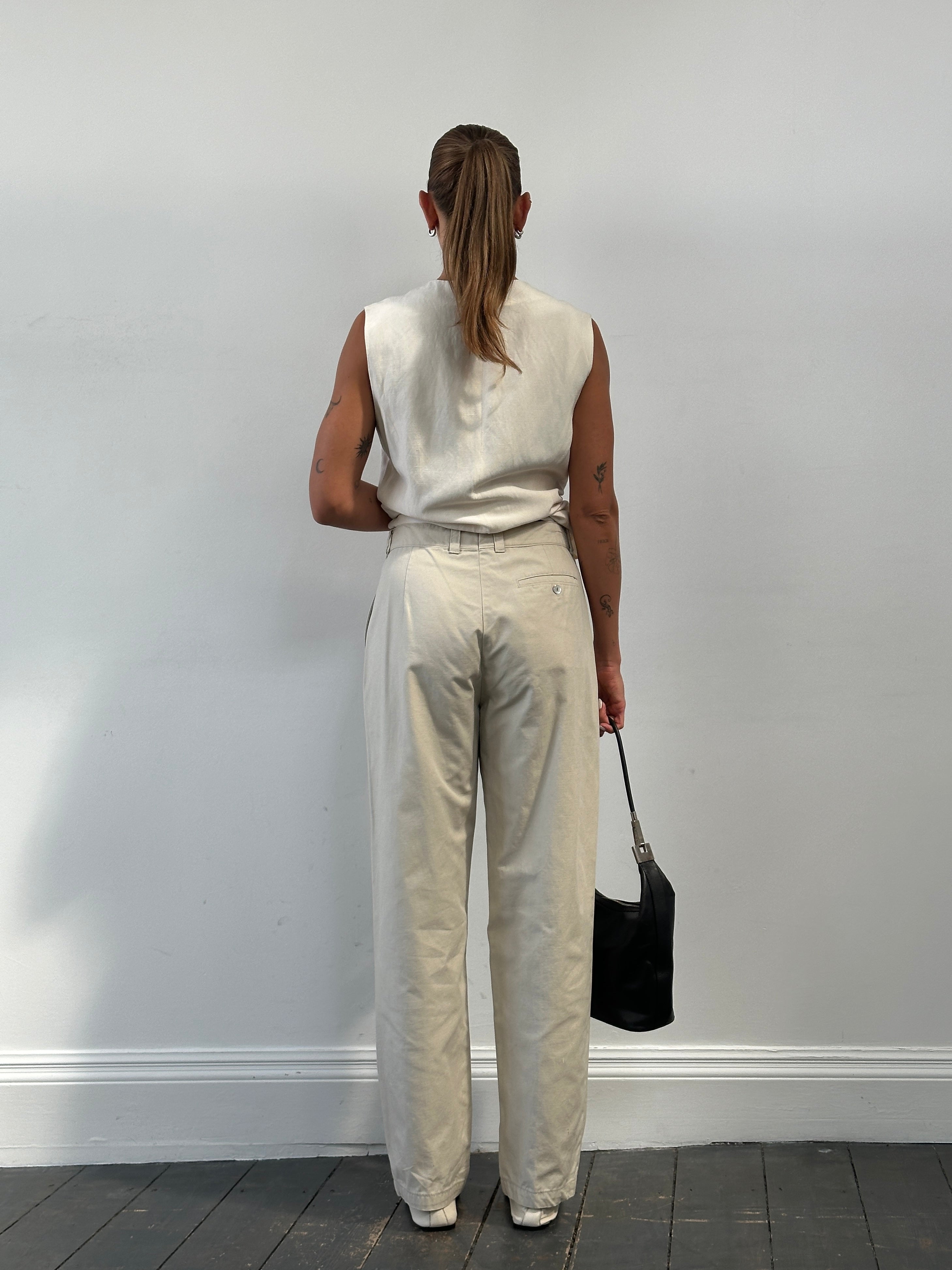 Vintage high waisted pleated trousers in W28 style, showing the classic fit and pleated front, made from lightweight fabric.