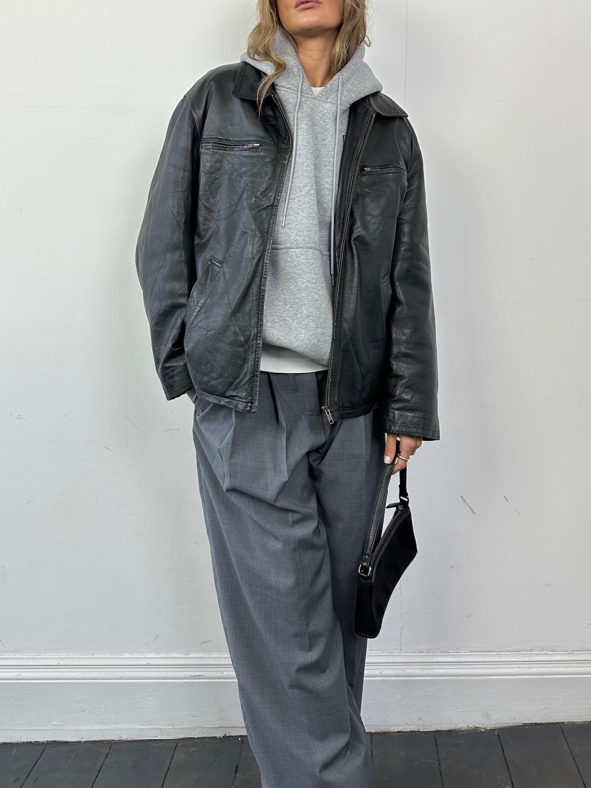 Black Conbipel leather zip-up jacket with a stand collar and front zipper, shown on a hanger. Medium-large size.