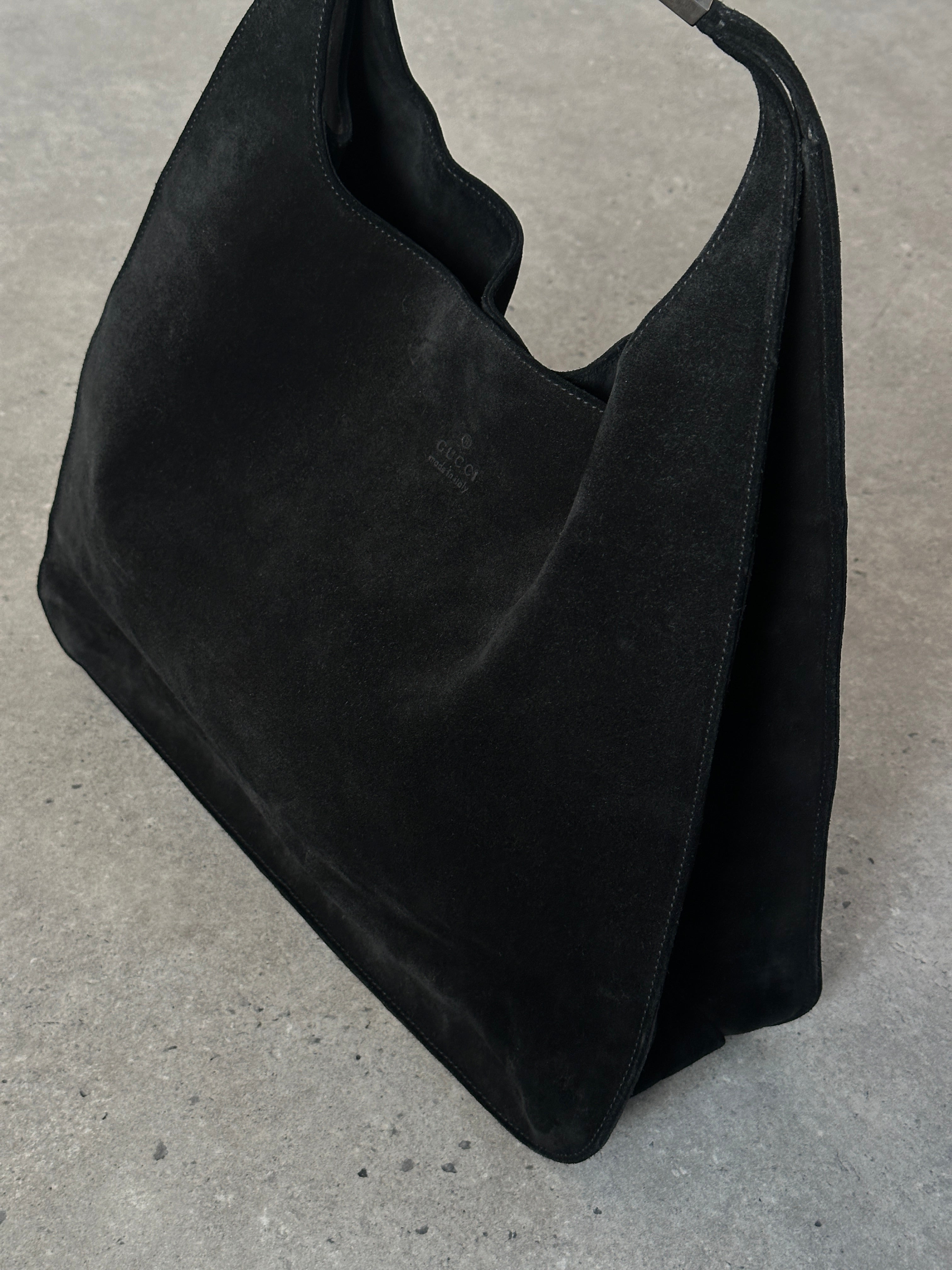 Gucci suede shoulder bag with elegant design, featuring a classic shape and subtle detailing on a neutral background.