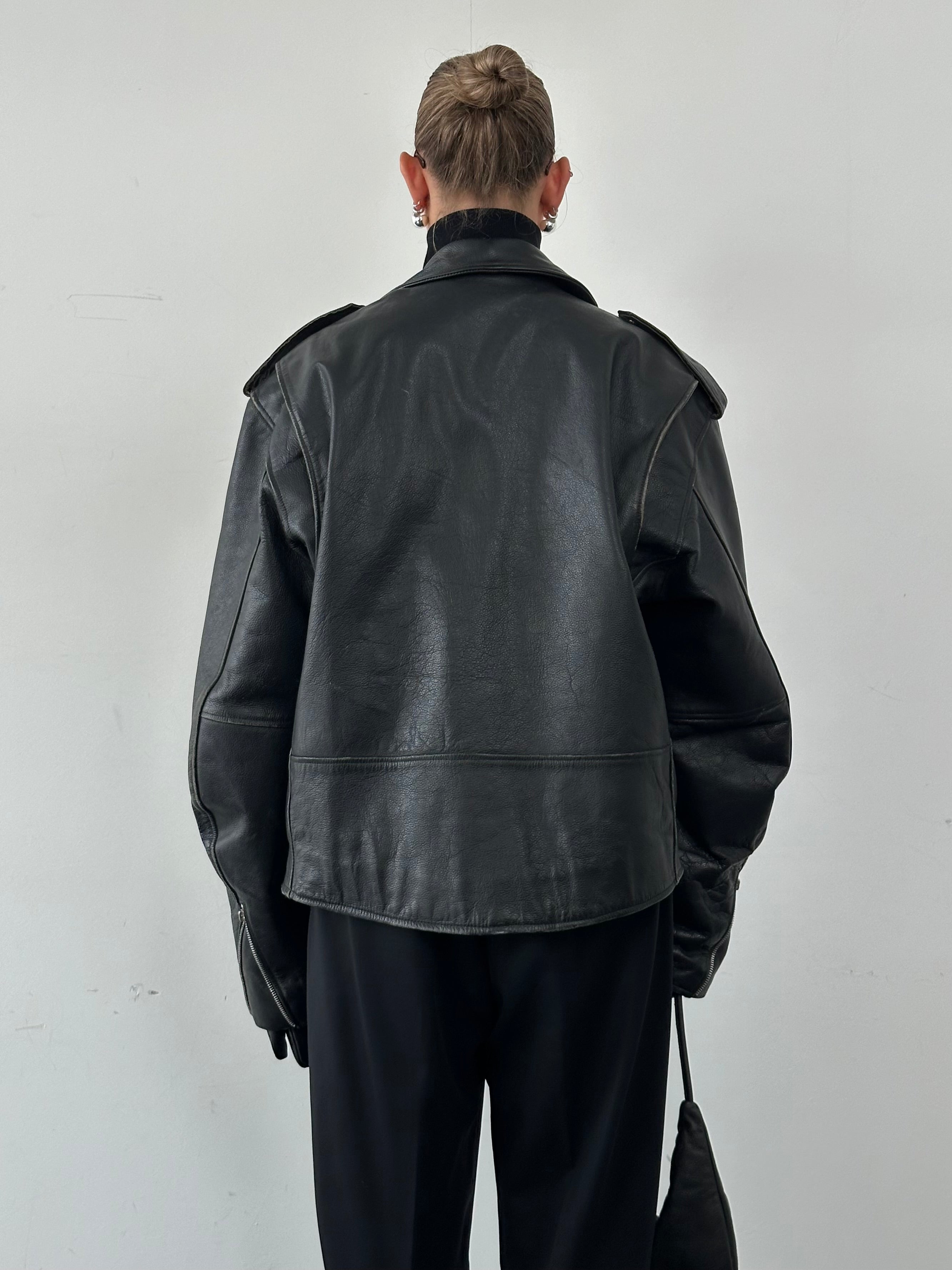 Vintage leather biker jacket in XL size showing classic design with metal zippers and distressed finish.