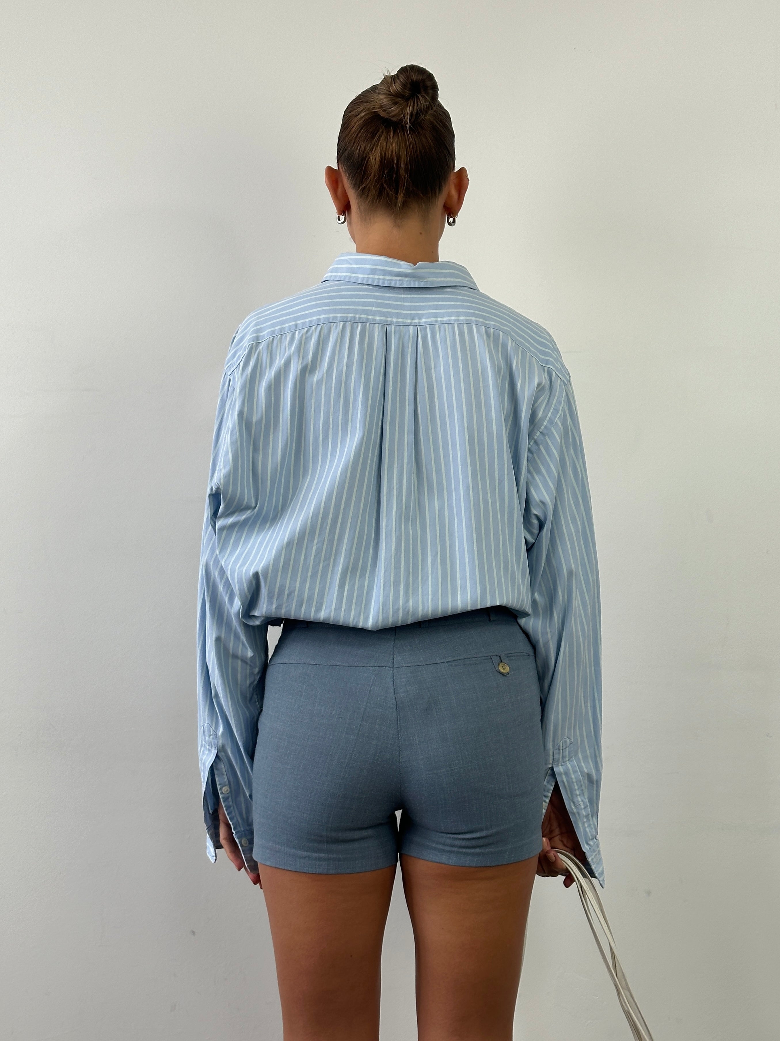 Vintage low-mid waisted tailored mini shorts with front pockets, showcasing a classic denim style and precise tailoring.