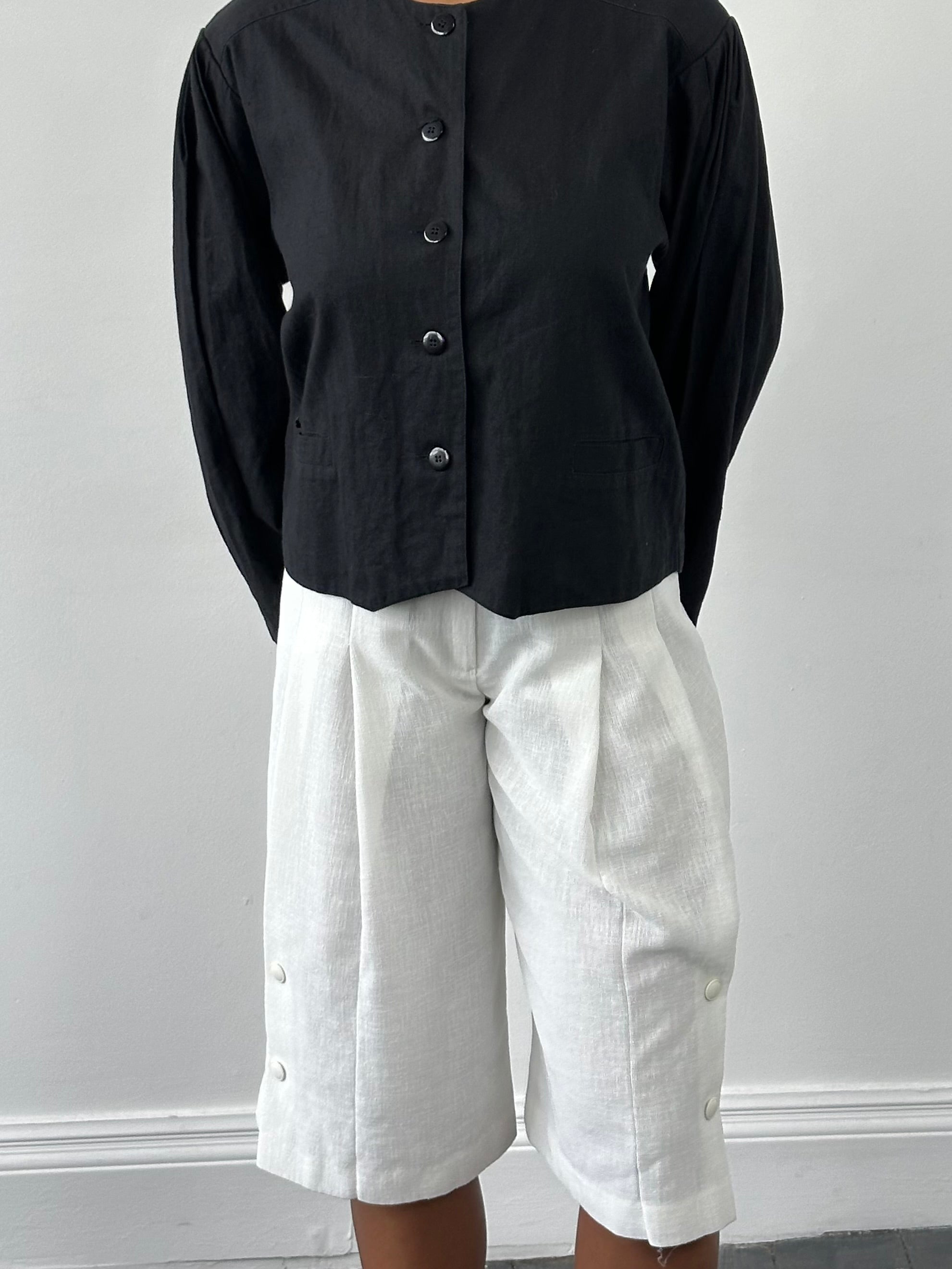 Vintage Japanese 1990s high-waisted pleated culottes shorts in beige, with a relaxed fit and side pockets.
