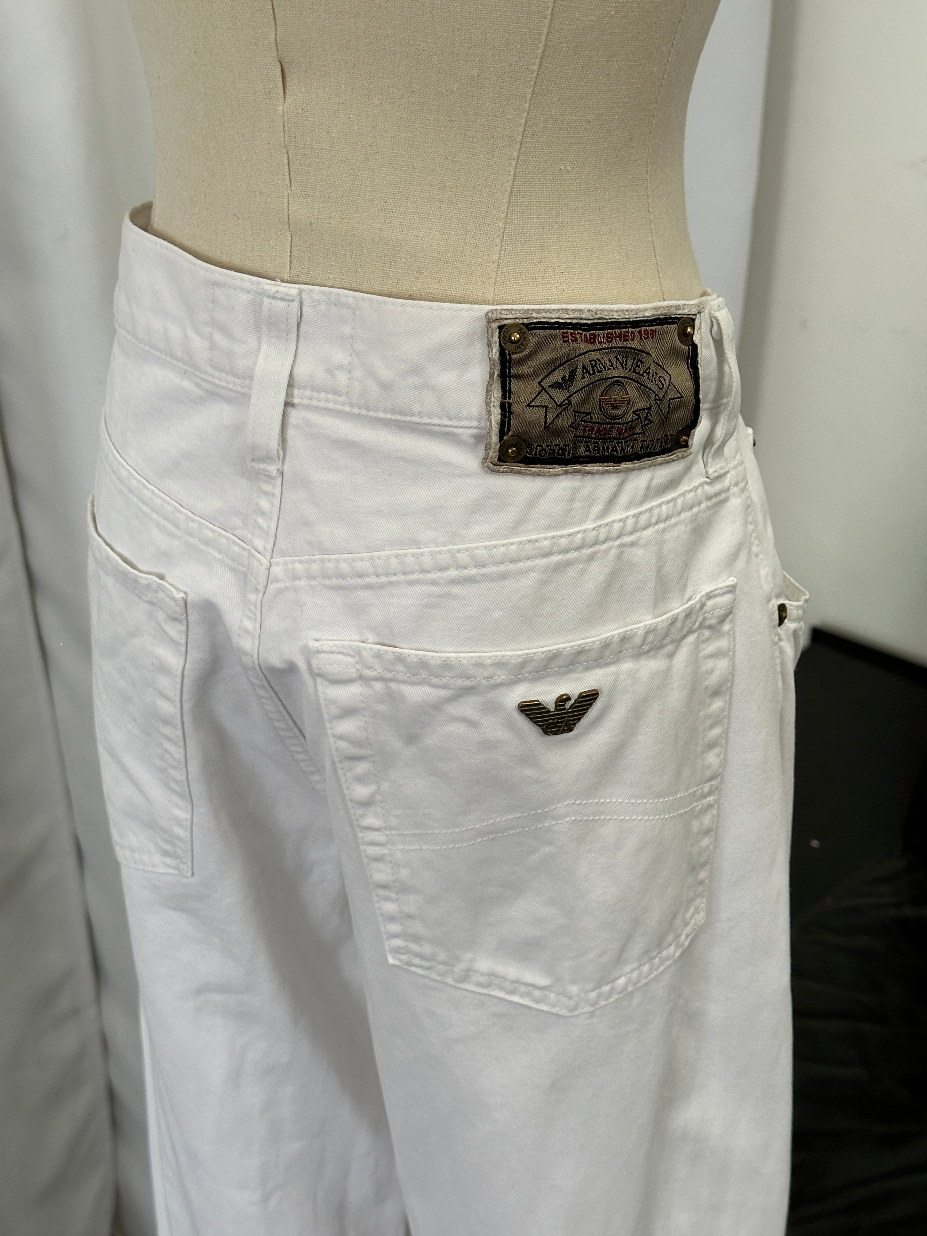Armani Jeans 1990s straight leg denim jeans in size W28, shown on a hanger with classic blue wash and minimal fading.