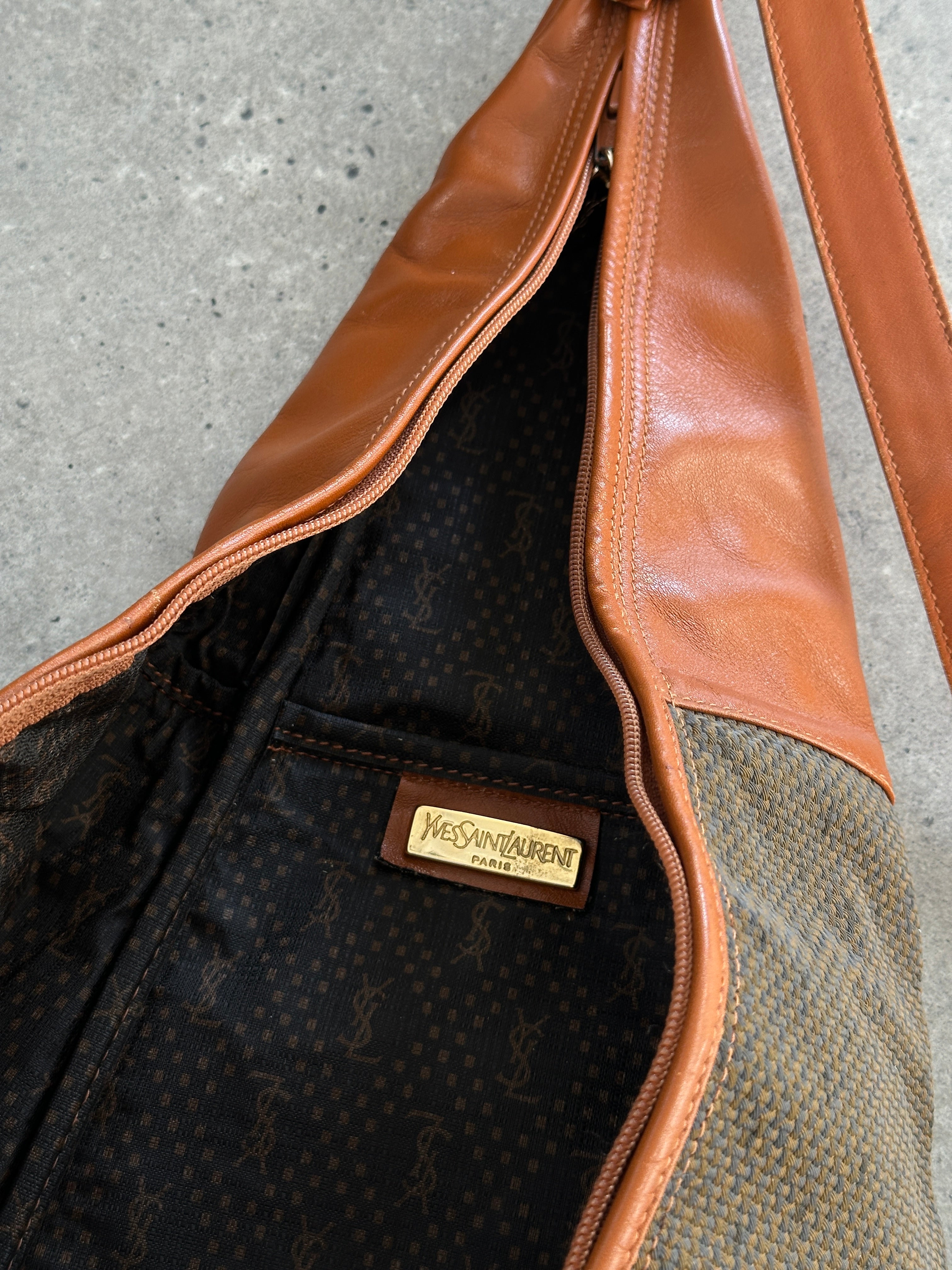 Yves Saint Laurent Paris 80s leather sling bag with adjustable strap and classic design, featuring black leather and gold-tone accents.