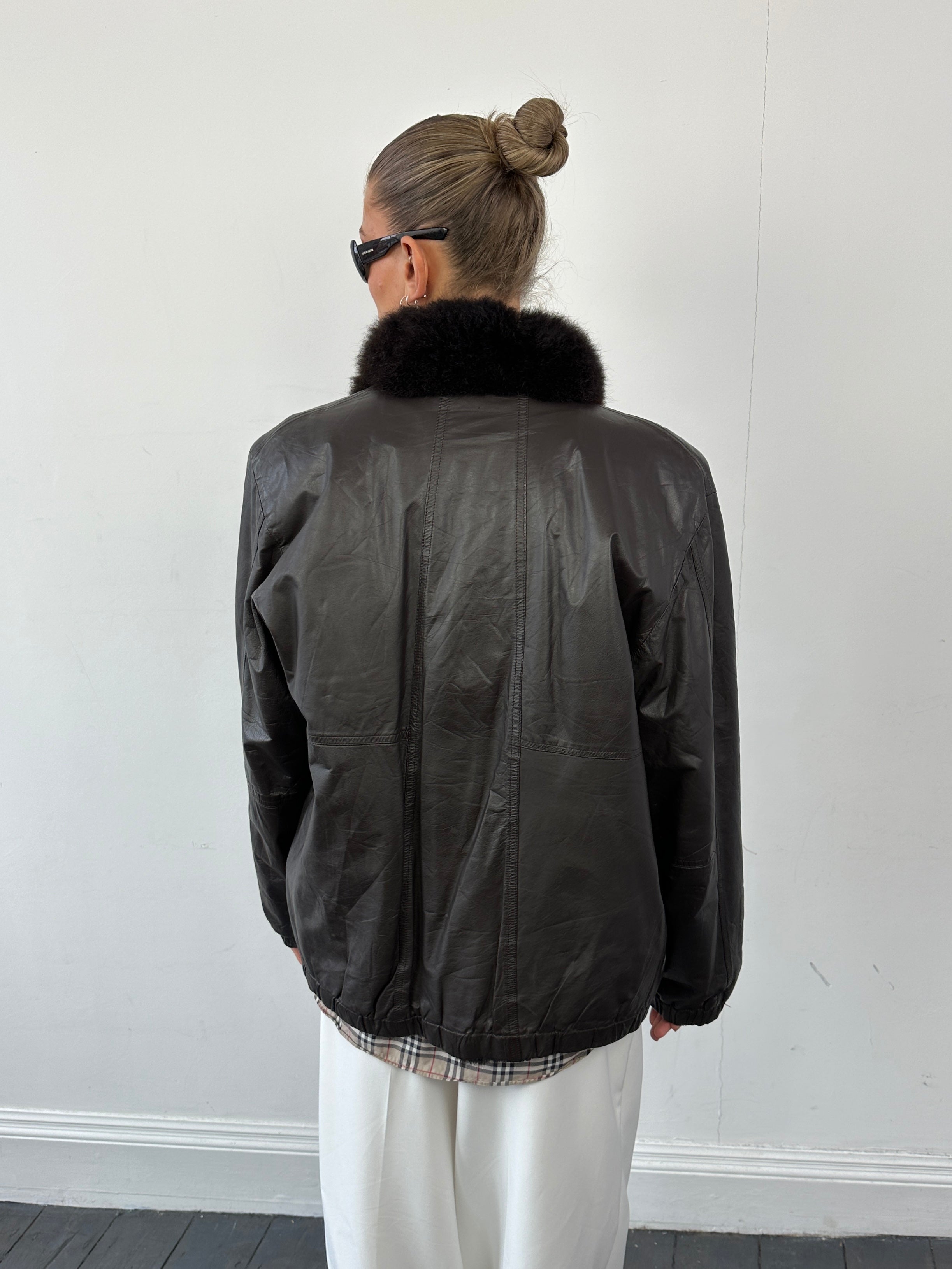 Vintage faux fur-lined minimal leather bomber jacket, size small, featuring sleek design and classic collar detail.
