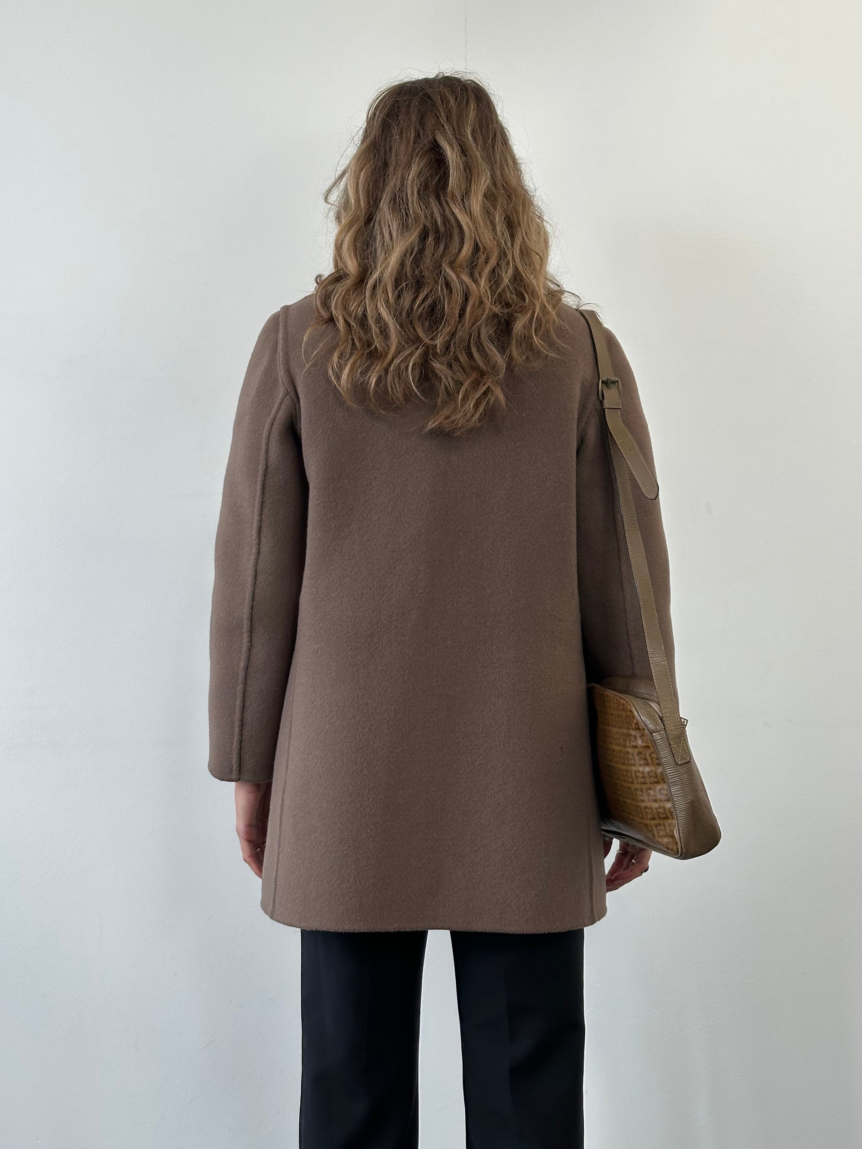 Vintage Italian vintage wool reversible belted coat, size M, shown hanging on a wooden hanger with a classic design.