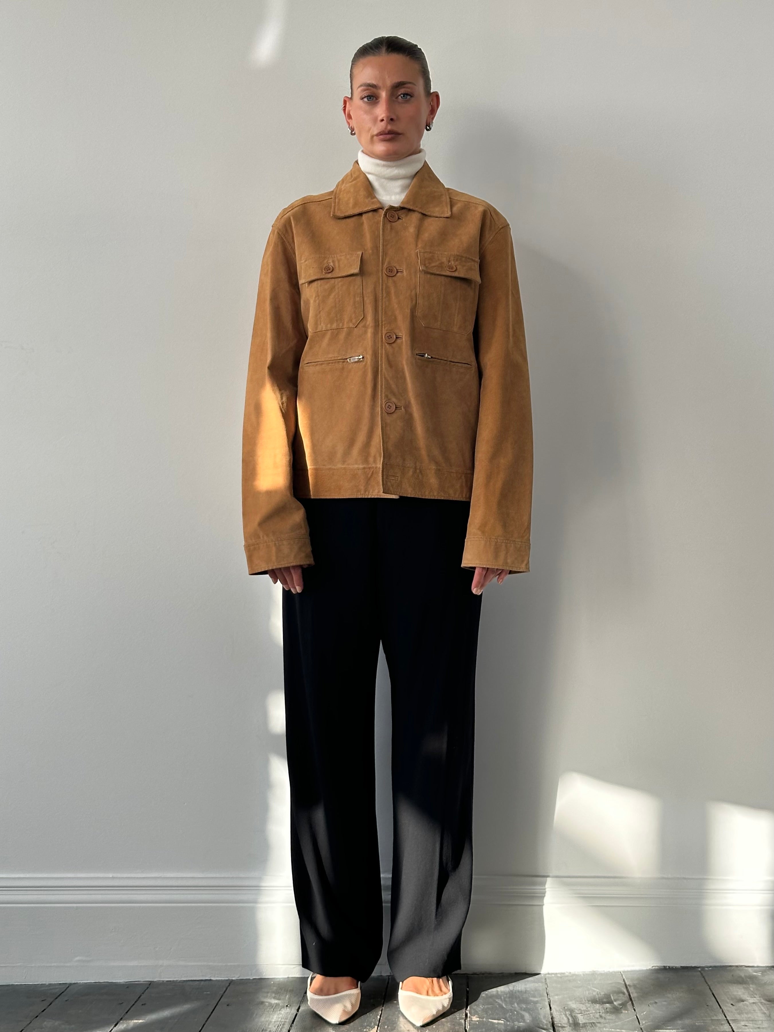 Vintage suede trucker jacket in size M/L, featuring classic design and rugged style, displayed on a hanger.