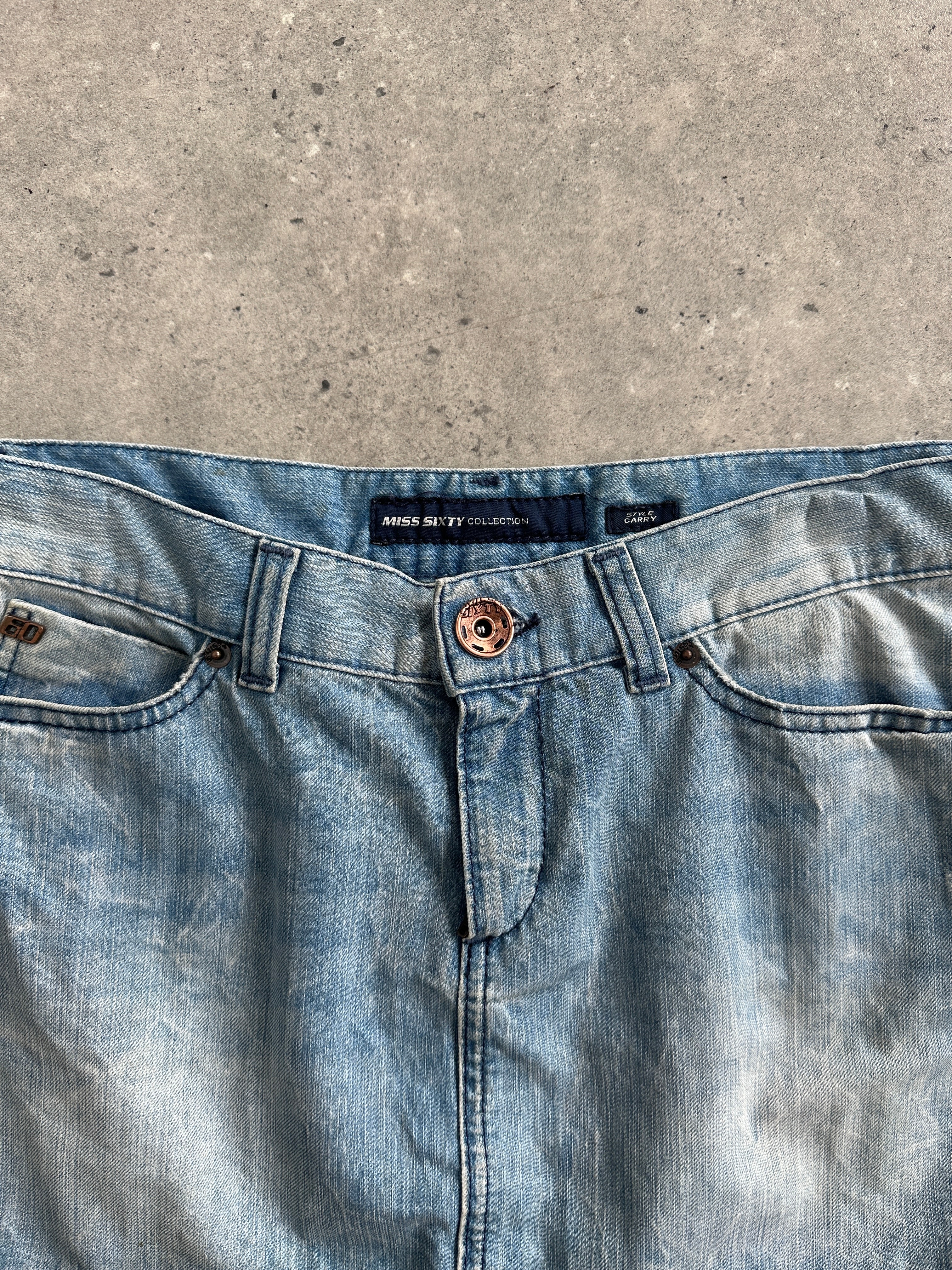 Miss Sixty 2000s denim mini skirt in W30, close-up of classic blue wash with frayed hem and button closure.
