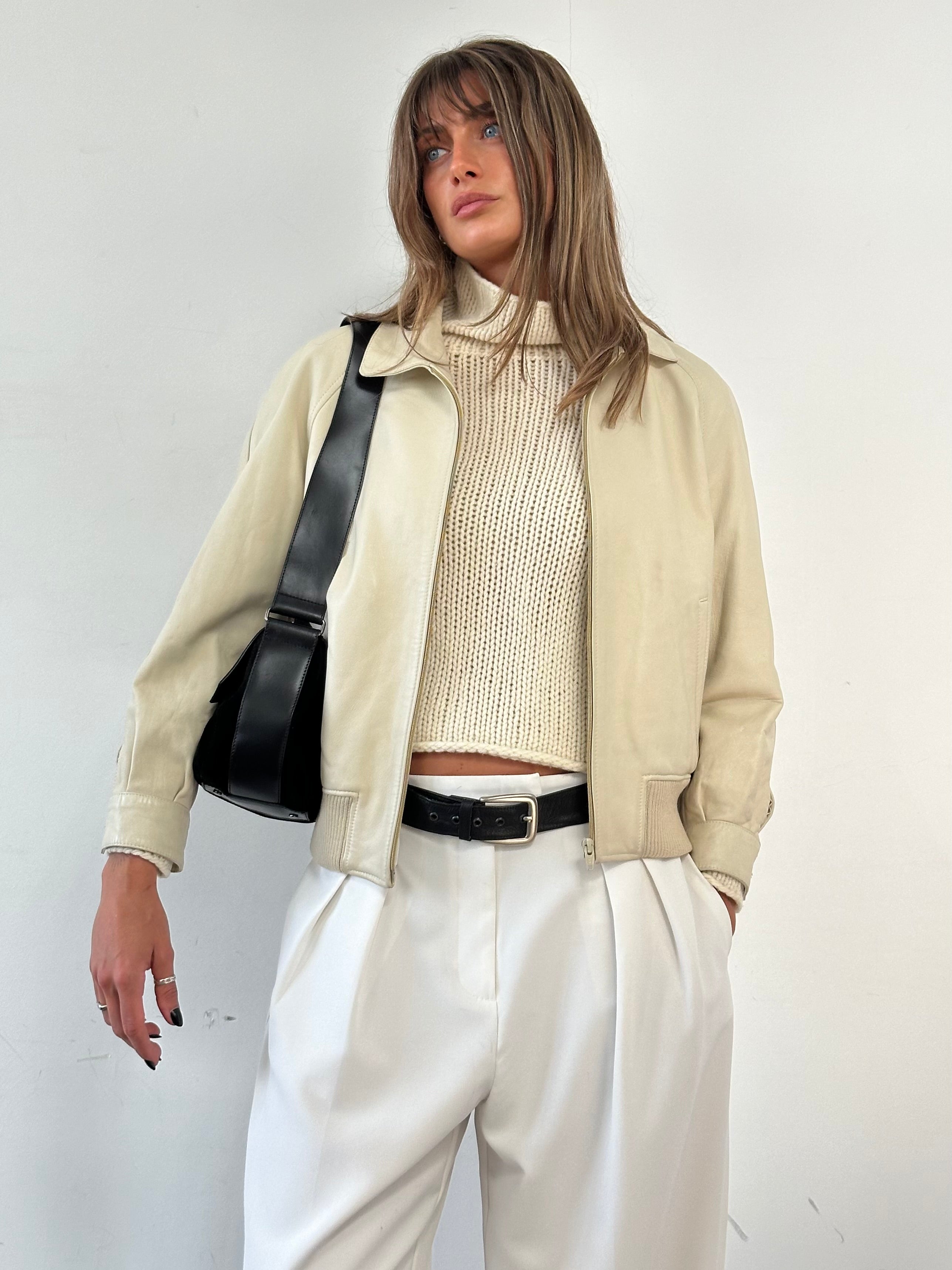 Vintage leather bomber jacket in size small, featuring classic design with ribbed cuffs and collar, shown in a natural stance.