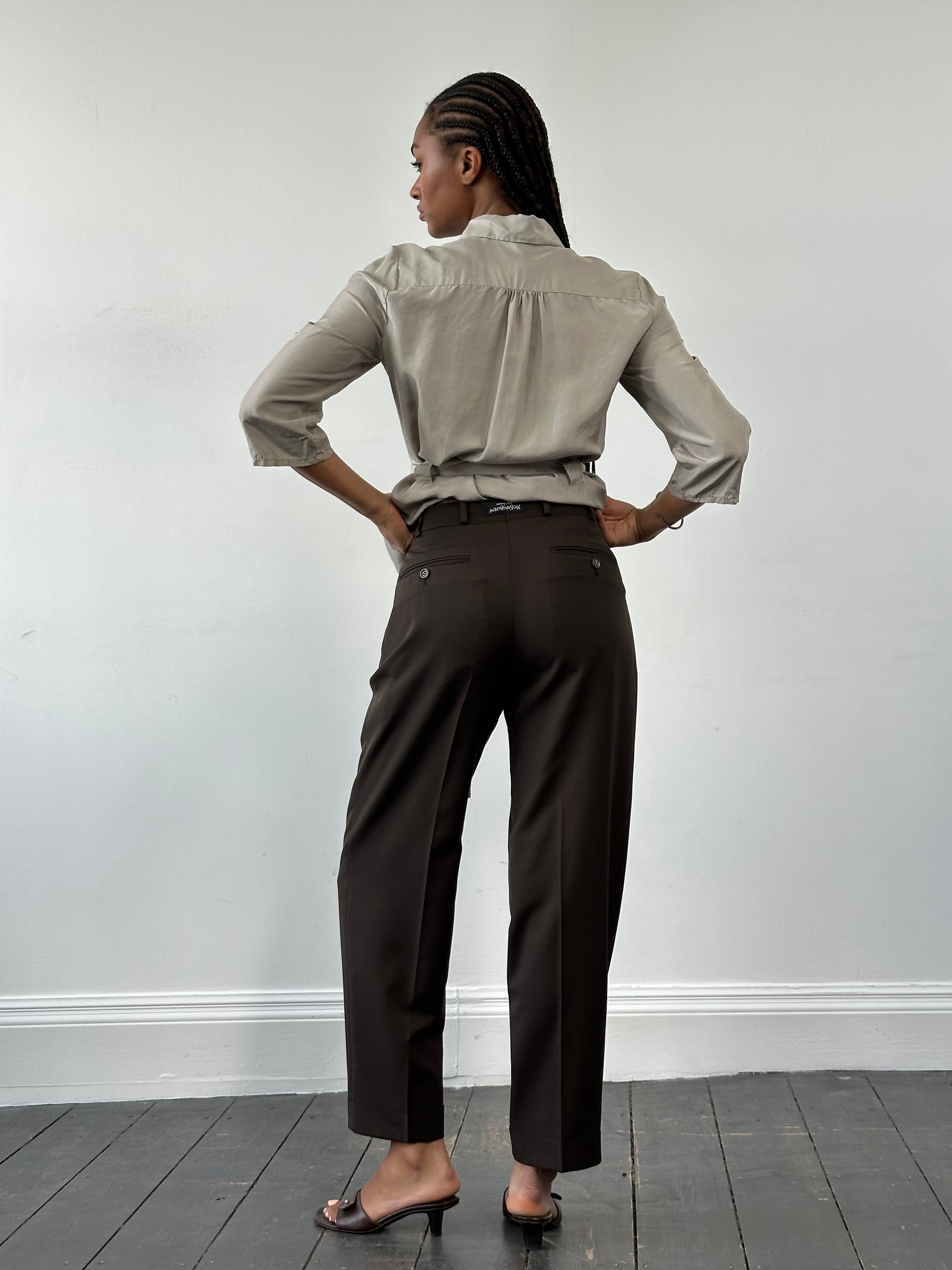 Yves Saint Laurent Pour Homme 1990s tailored wool trousers in dark color, showing a close-up of the waistband and fabric texture.