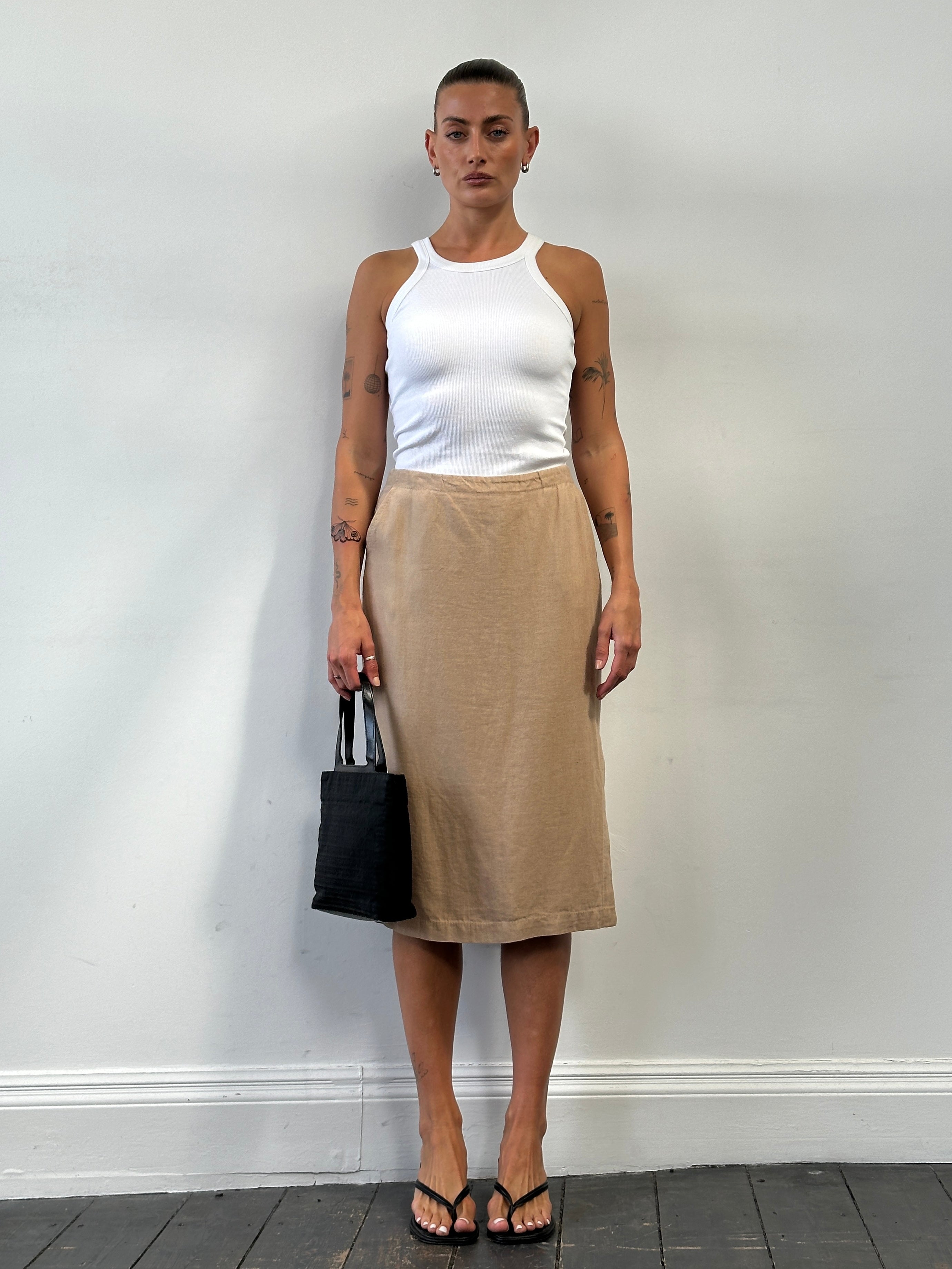 Max Mara pure linen midi skirt in W28 showcased in natural light, highlighting its flowy fabric and elegant design.