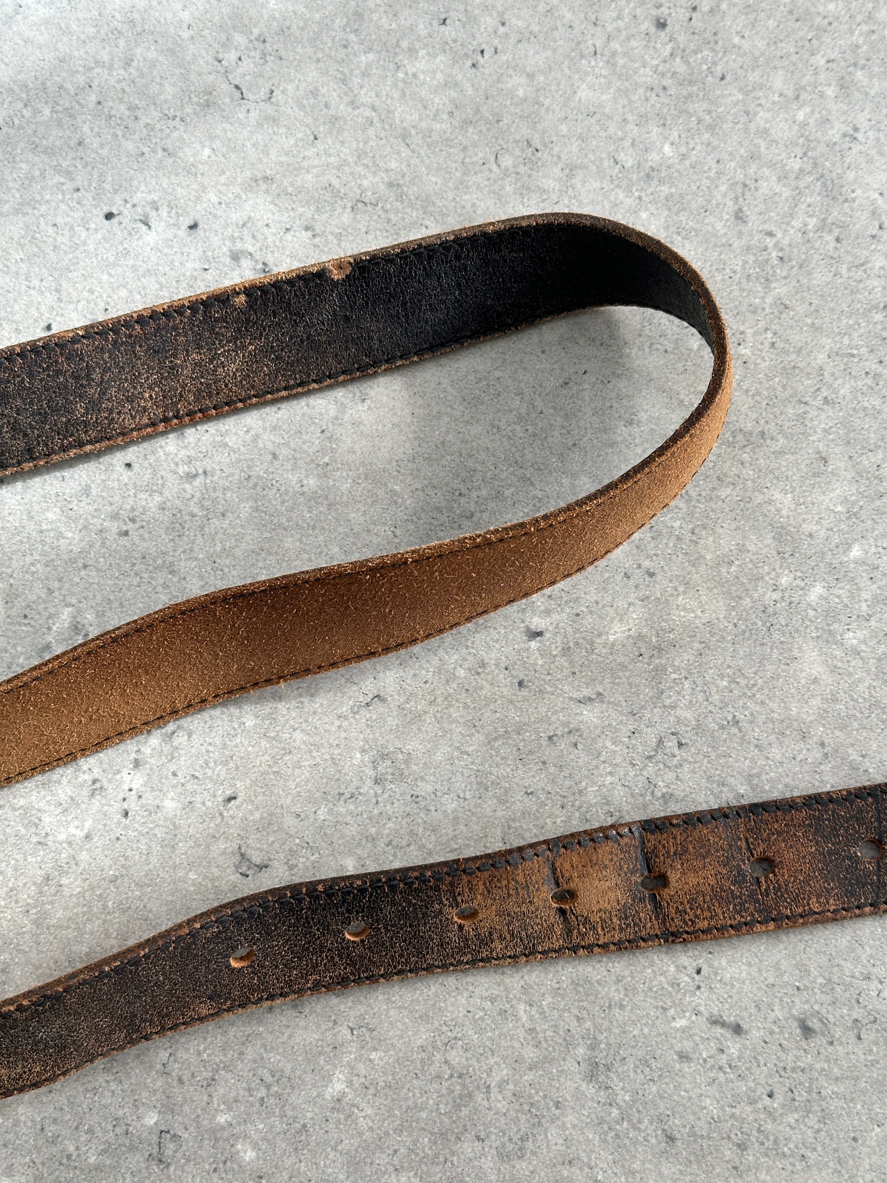 Vintage 1980s distressed leather belt with adjustable W27-35, featuring a rugged, worn-in look and classic leather craftsmanship.