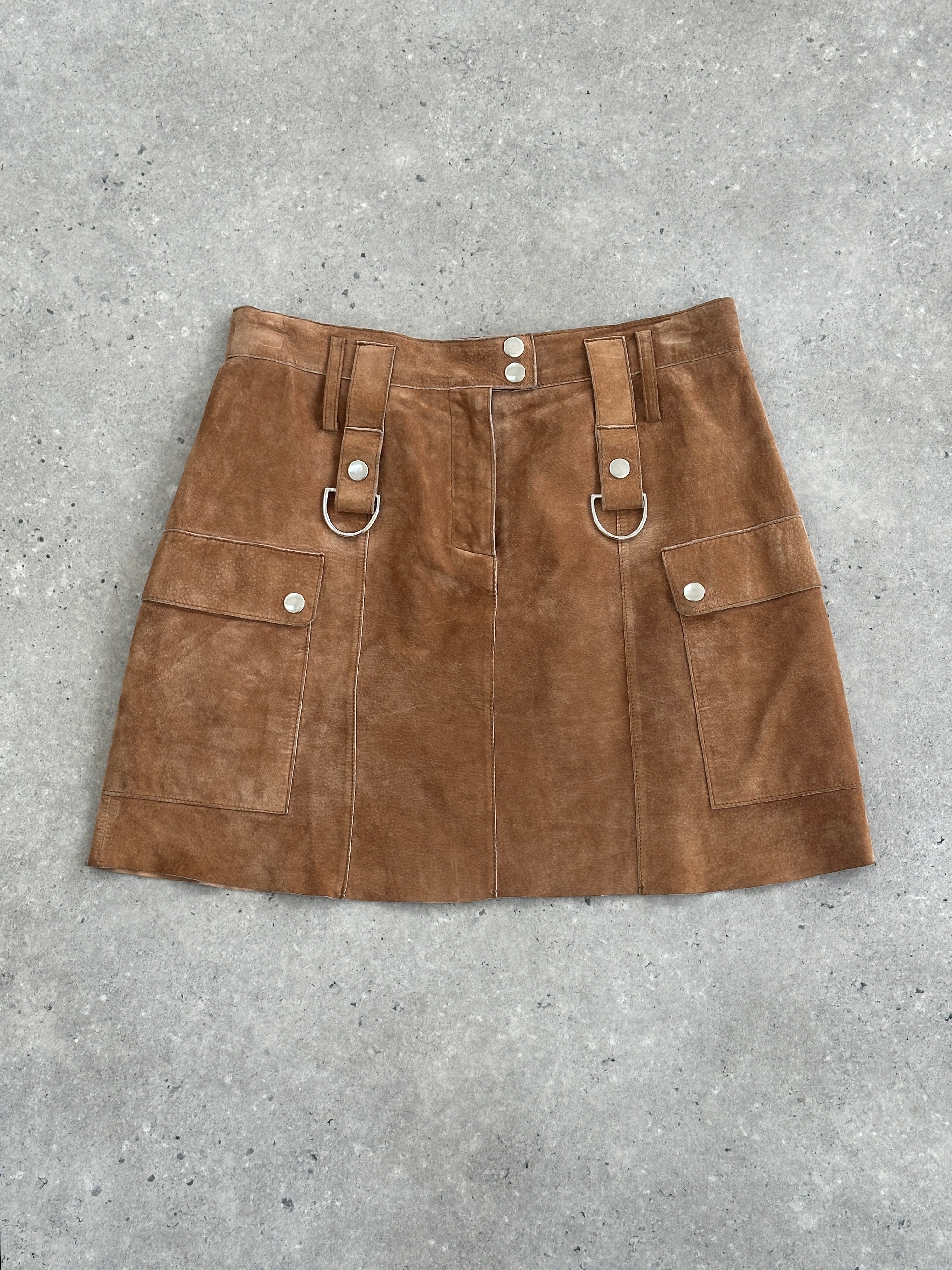 Conbipel suede mini skirt in size W28, stylish and fitted with a smooth suede texture, displayed on a flat surface.