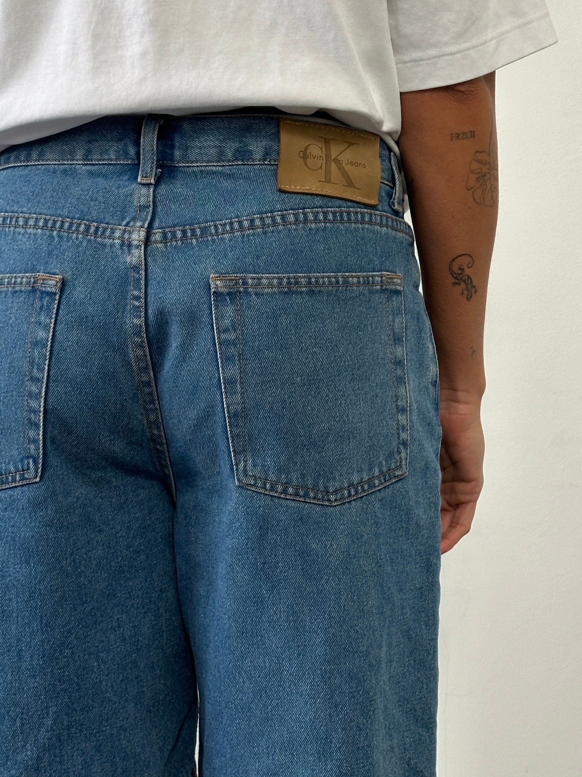 Calvin Klein CK loose leg denim shorts in W32 with distressed details and a relaxed fit, displayed on a neutral background.