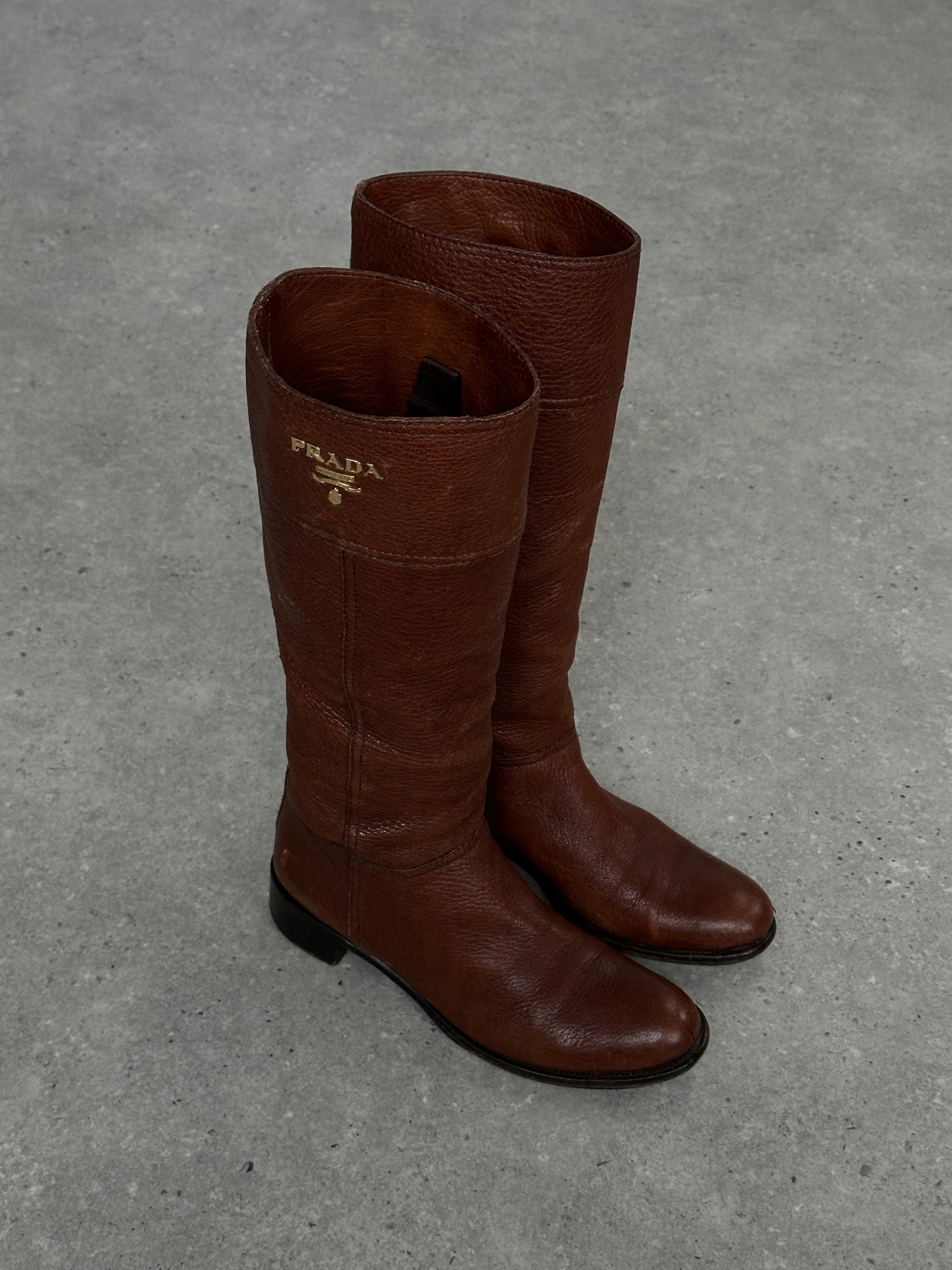 Prada leather knee boots in black with logo detailing, UK size 4, EUR 37, featuring a sleek design and pointed toe.