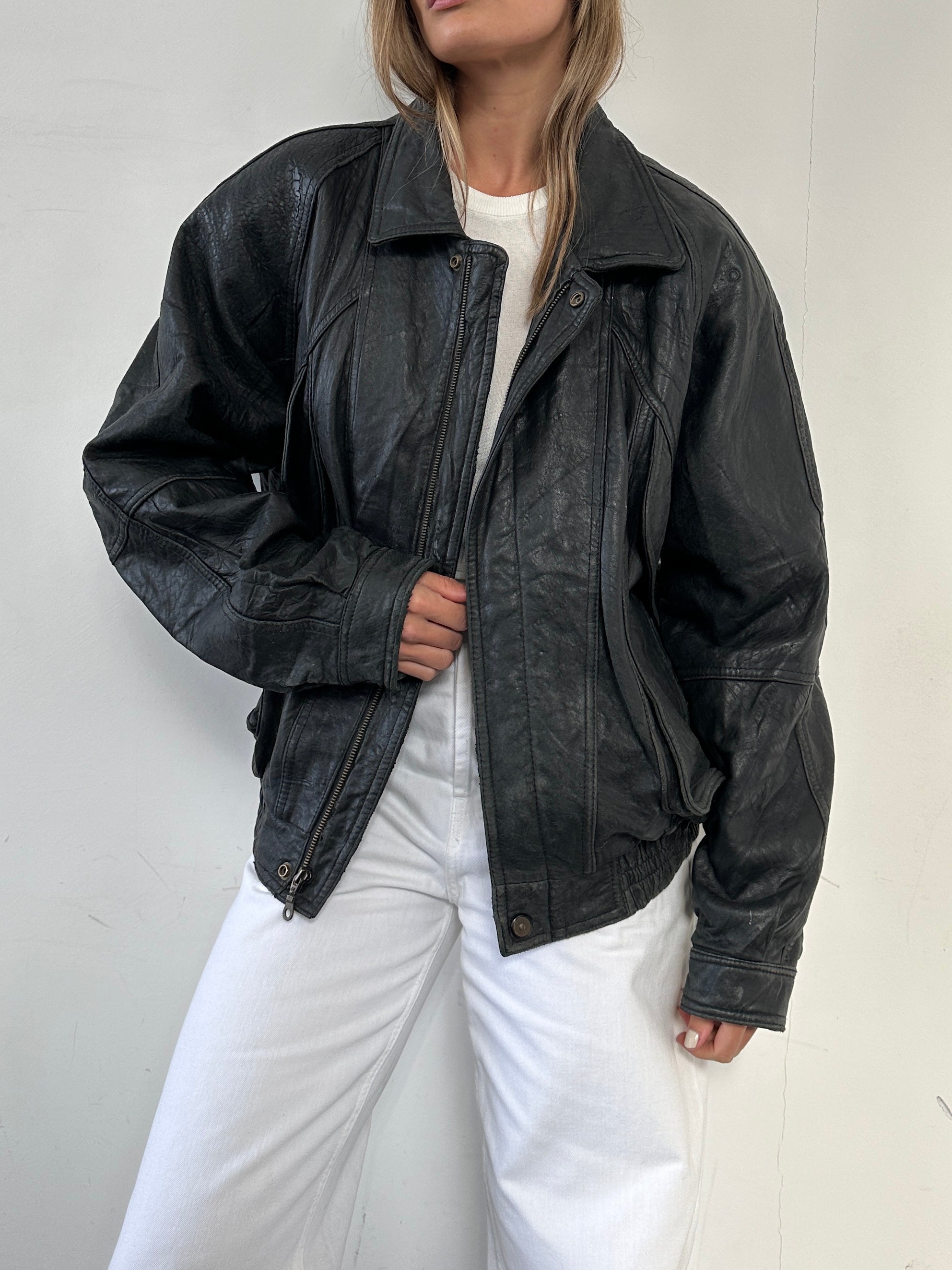 Vintage distressed leather bomber jacket in size large, featuring rugged texture and classic design from the Vintage brand.