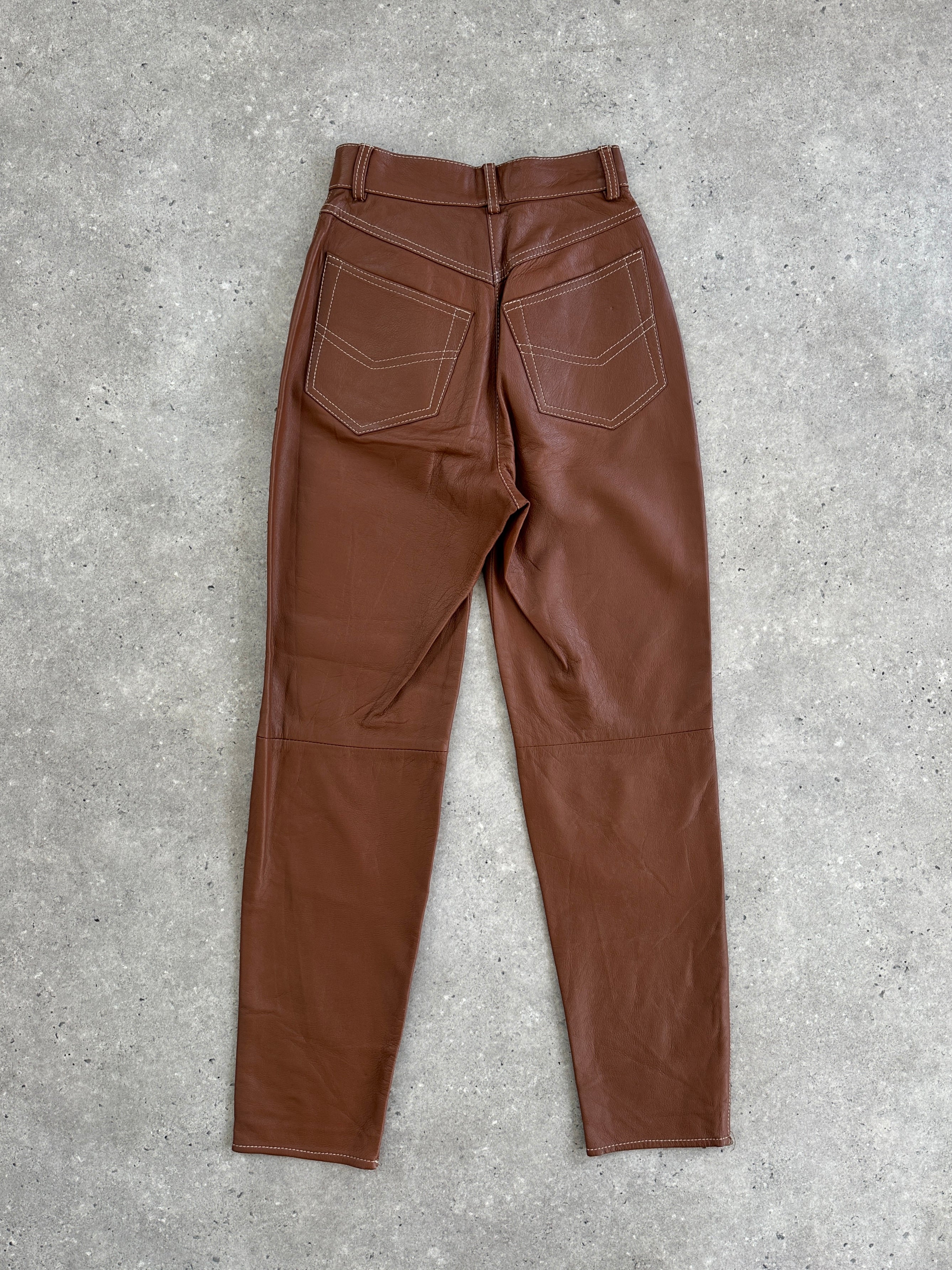 Vintage Italian high-waisted tapered leather trousers with a vintage style, featuring a high waist and tapered leg fit.