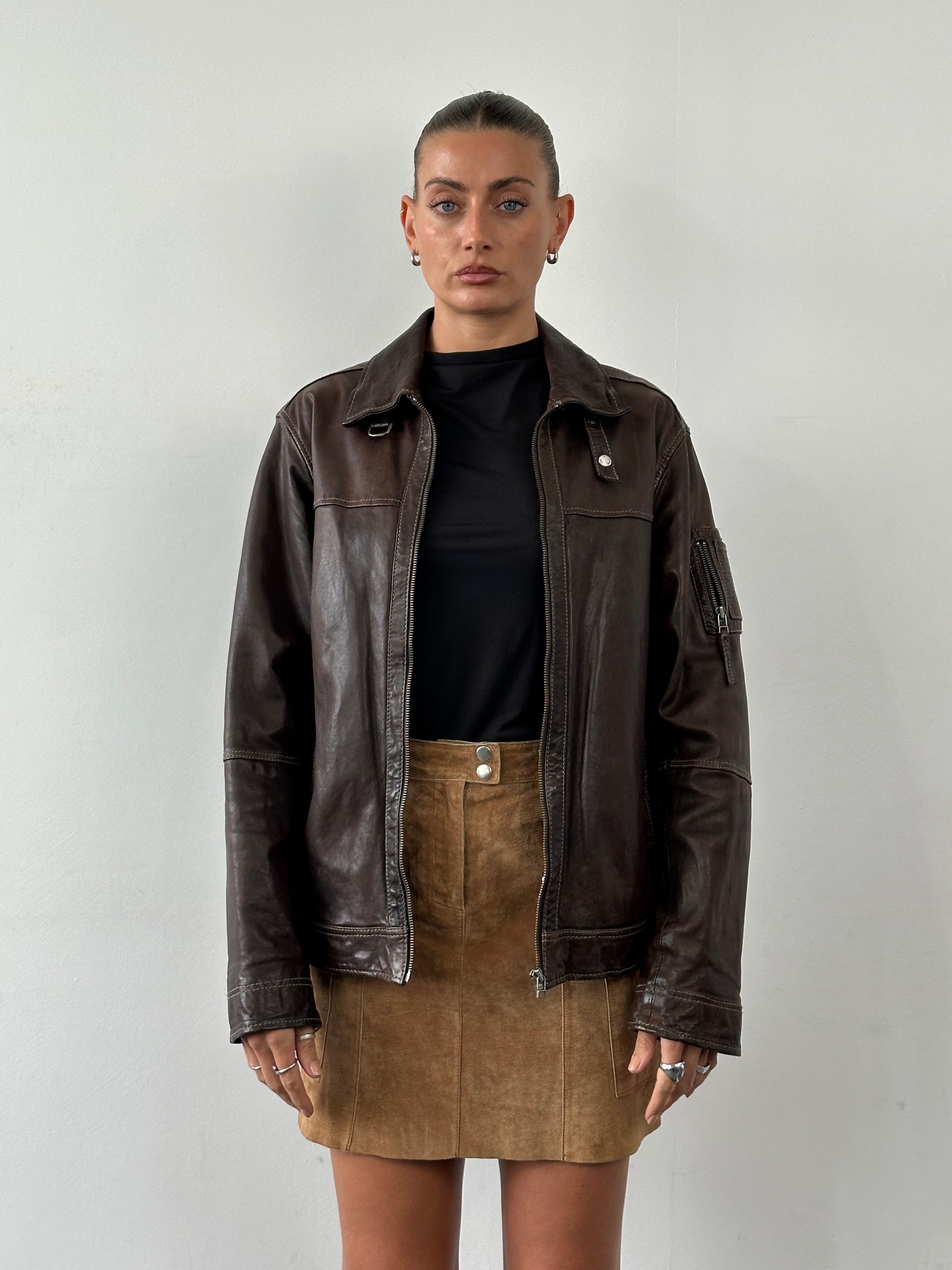 Vintage Moto aged leather jacket in size large, featuring classic design and worn-in texture, showcased on a hanger.