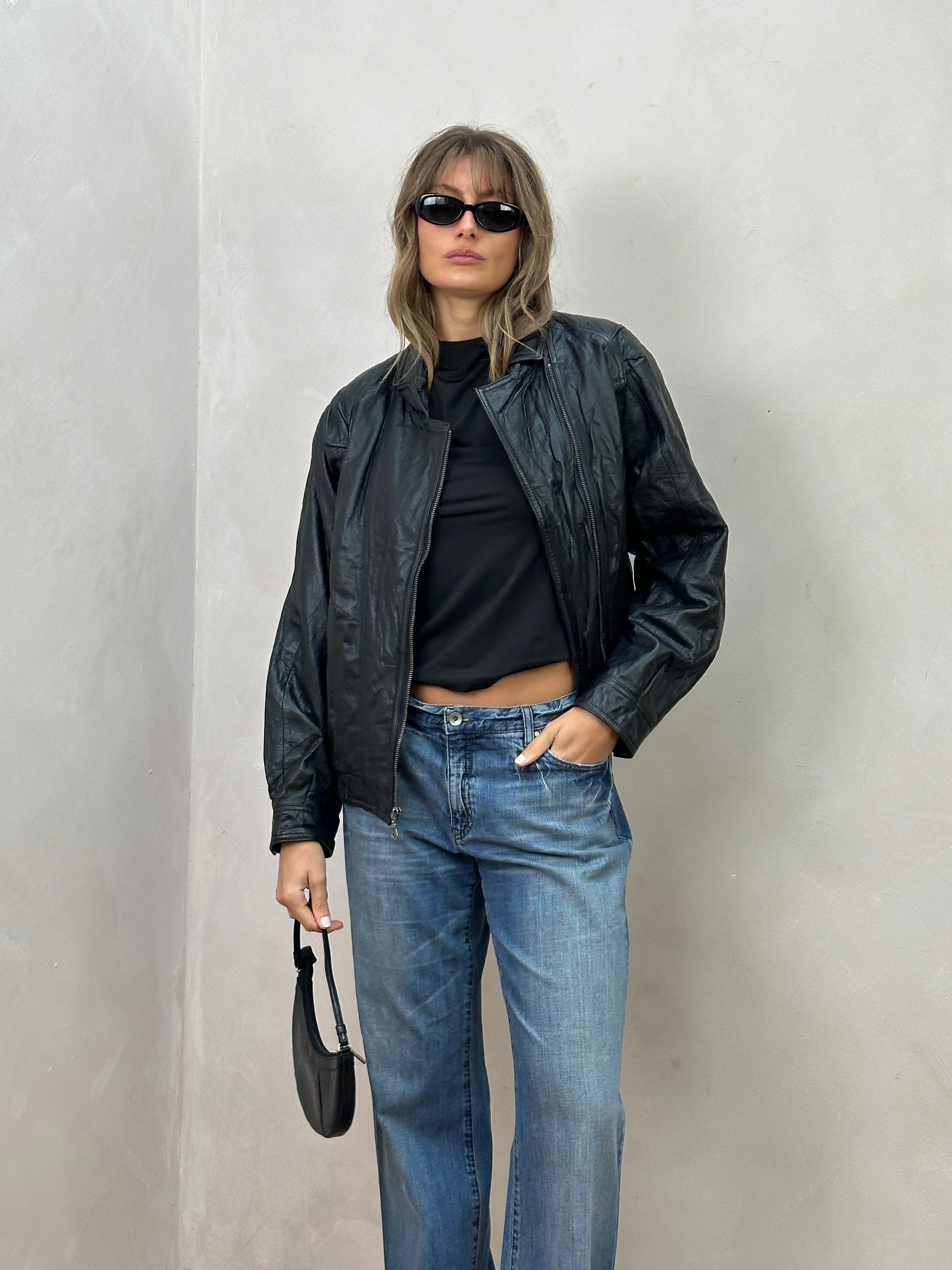 Vintage leather biker jacket in size small/medium, featuring classic design, rugged texture, and detailed stitching.