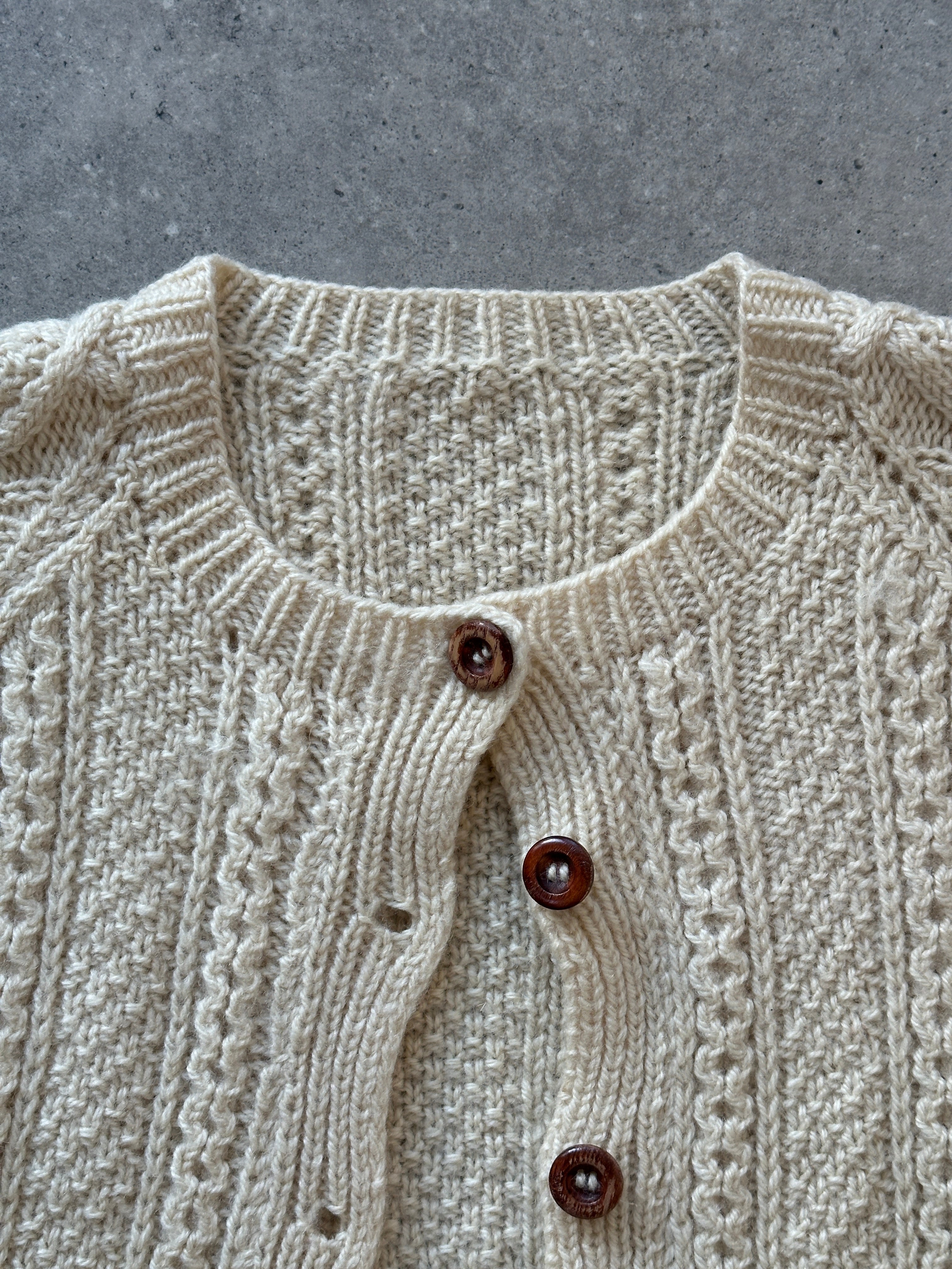 Vintage wool cable knit cardigan in size large, featuring a classic textured pattern and button-up front.