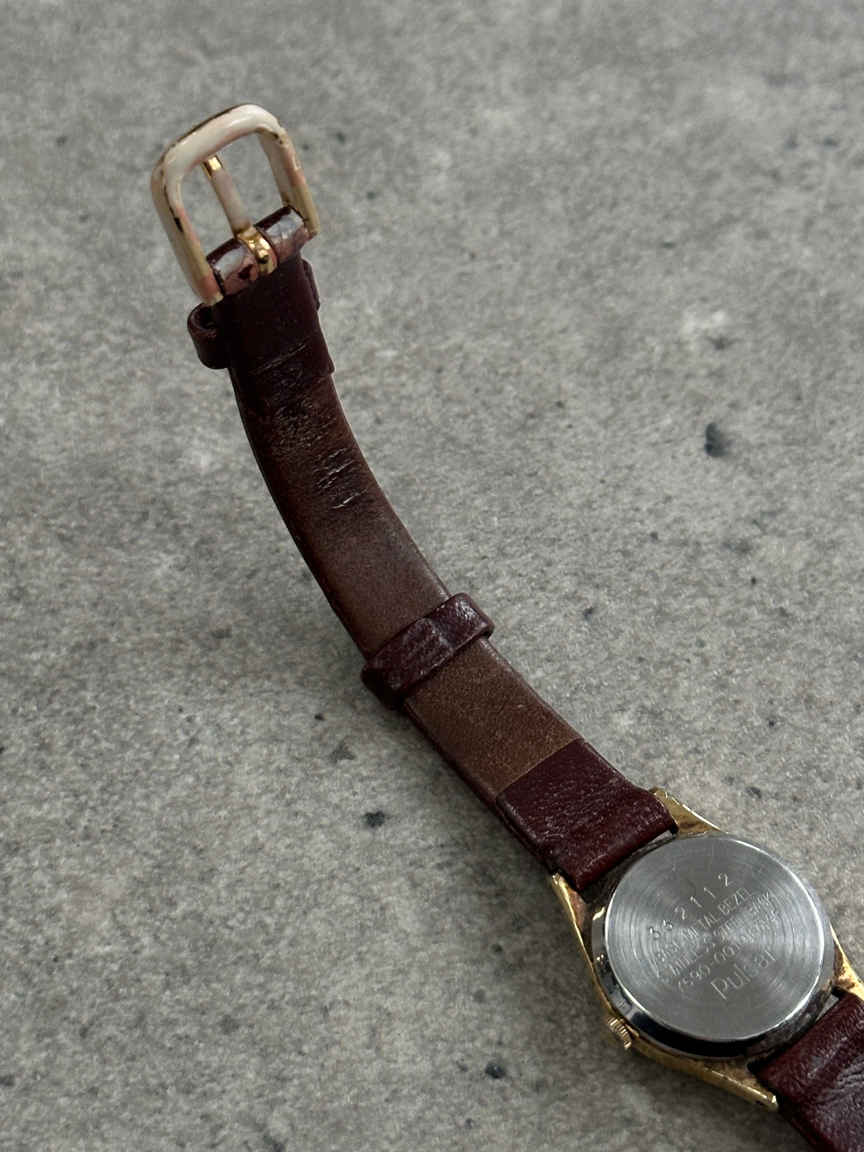 Pulsar 1990s gold-tone round quartz watch with a classic design and analog display, featuring a sleek gold finish.