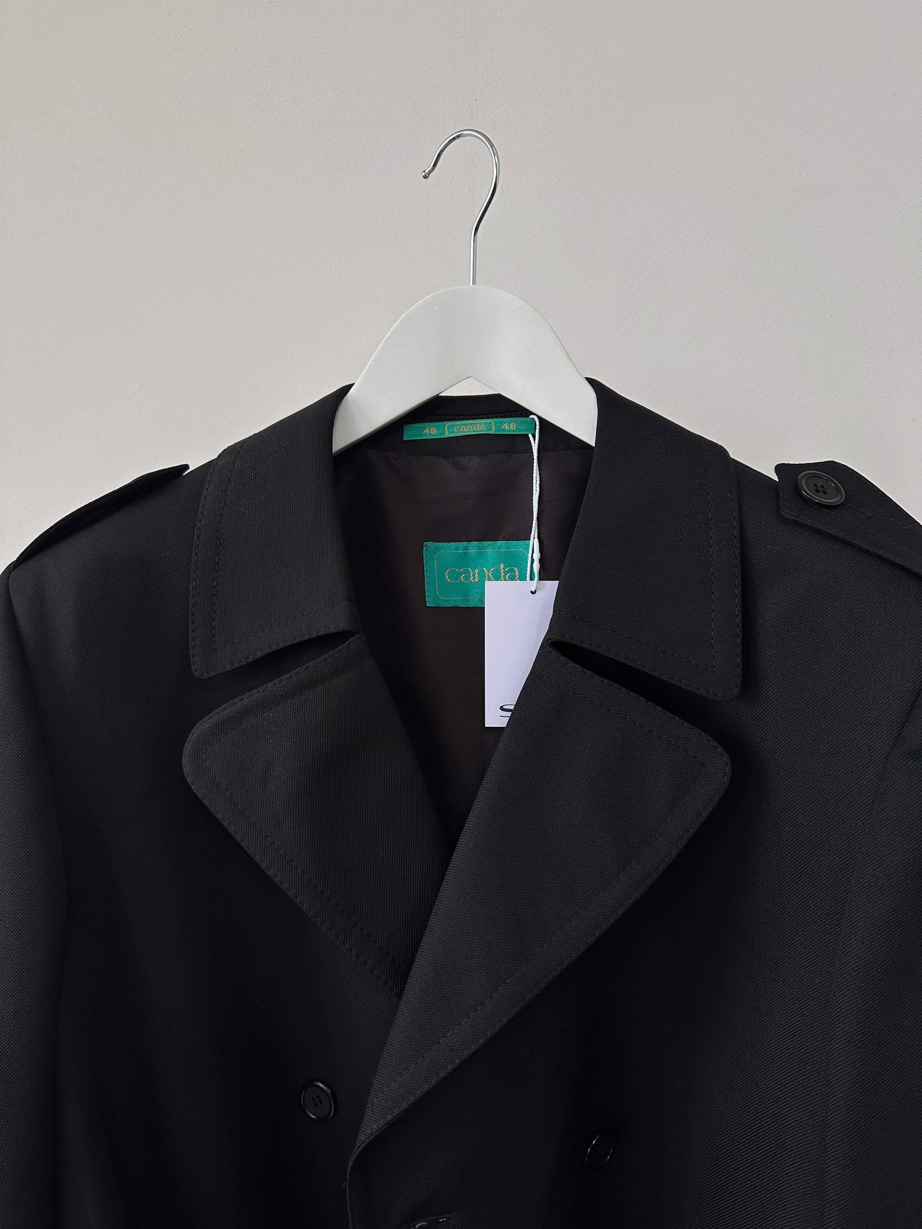Vintage double-breasted belted trench coat, size large, with classic design and neutral color, displayed on a hanger.