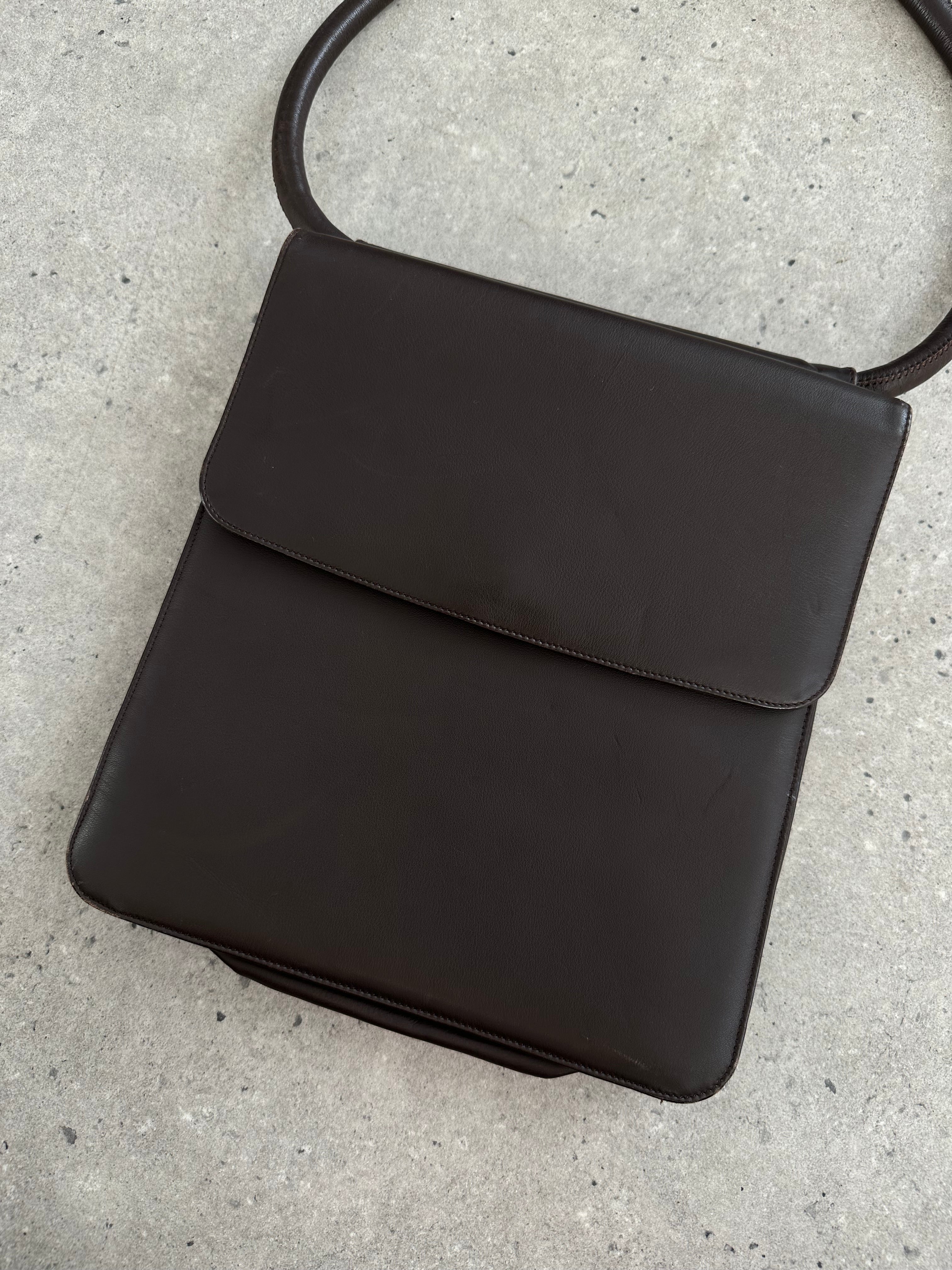 Giorgio Armani Le Collezioni leather shoulder bag with sleek design and adjustable strap, featuring a smooth finish and minimal branding.
