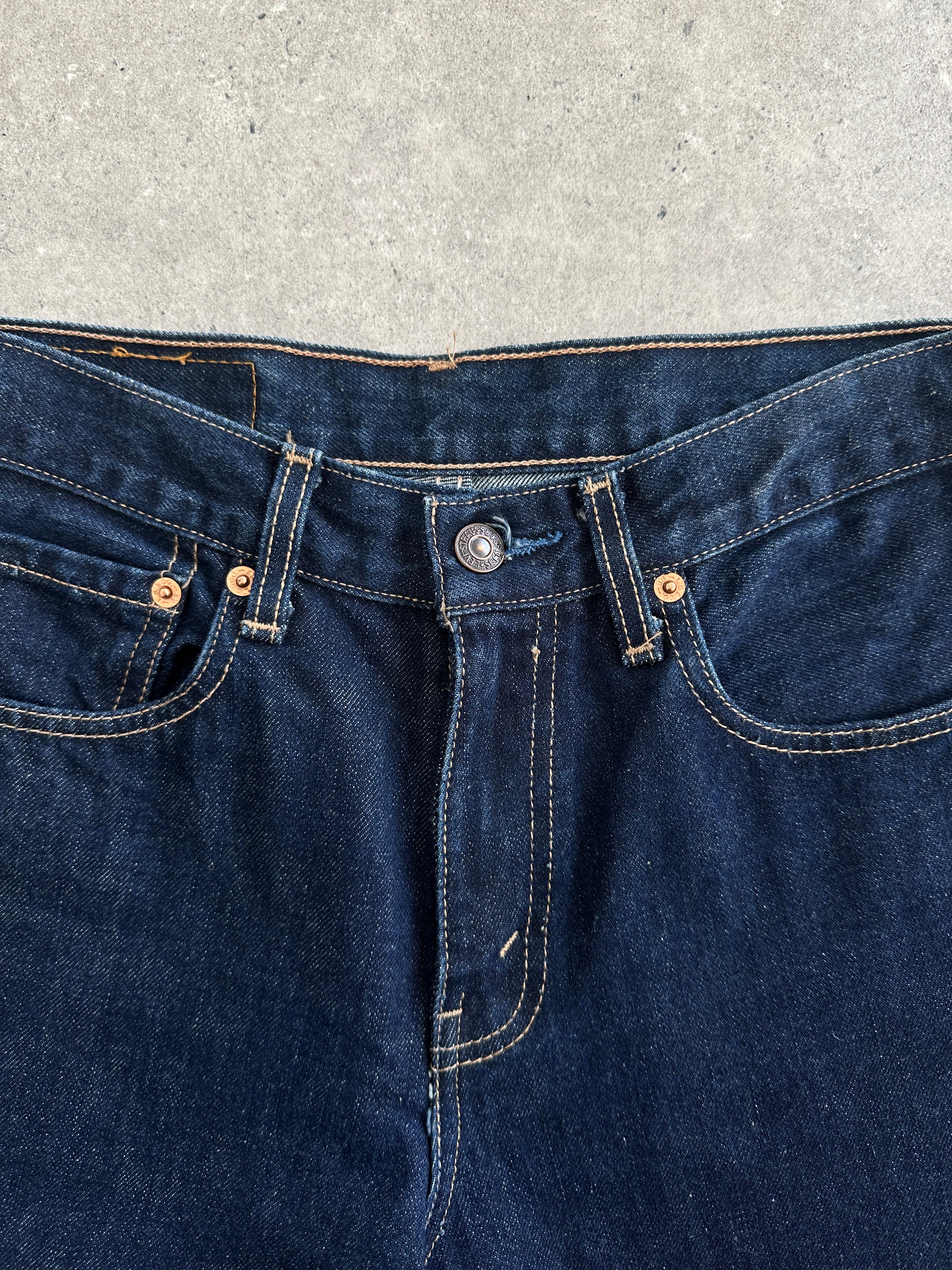 Levi’s 525 mid-rise denim bootcut jeans in W26, showcasing classic blue wash and fitted waist on a model.